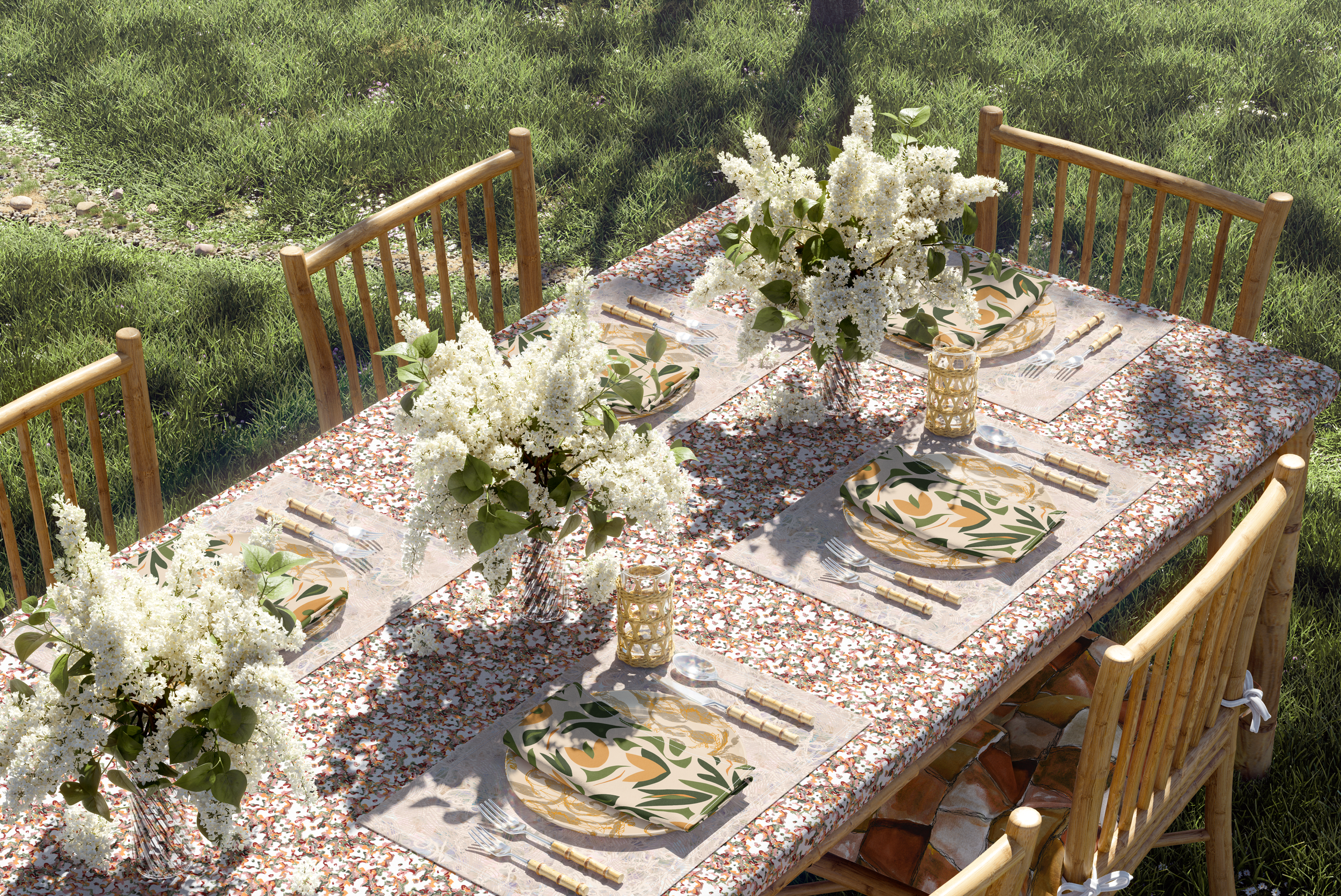 An outdoor dining table set with white floral centerpieces, patterned napkins, and candles, surrounded by wooden chairs on a grassy area.