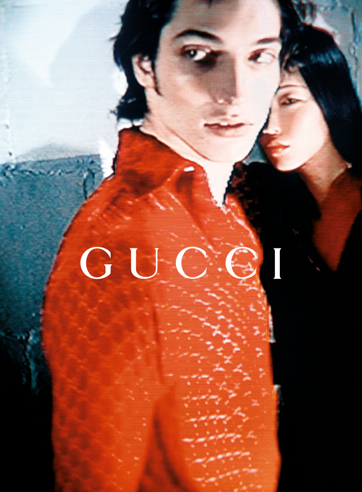 BACKGROUNDED AND BLURRED:
The Asian woman is literally placed behind the white male figure, partially obscured and visually subordinate. Her presence signals “diversity,” but the framing preserves the hierarchy: visibility without voice, inclusion wi