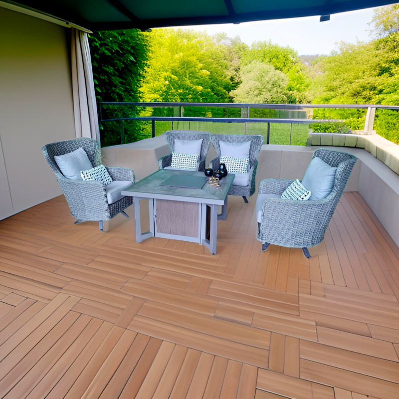 Sala de estar al aire libre con sillones de mimbre, cojines y una mesa de vidrio en una terraza con vista a árboles verdes.