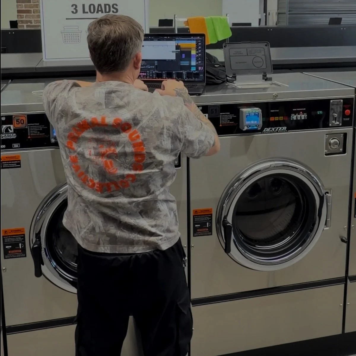 PRTTYUGLY producing music on a laptop in a laundromat