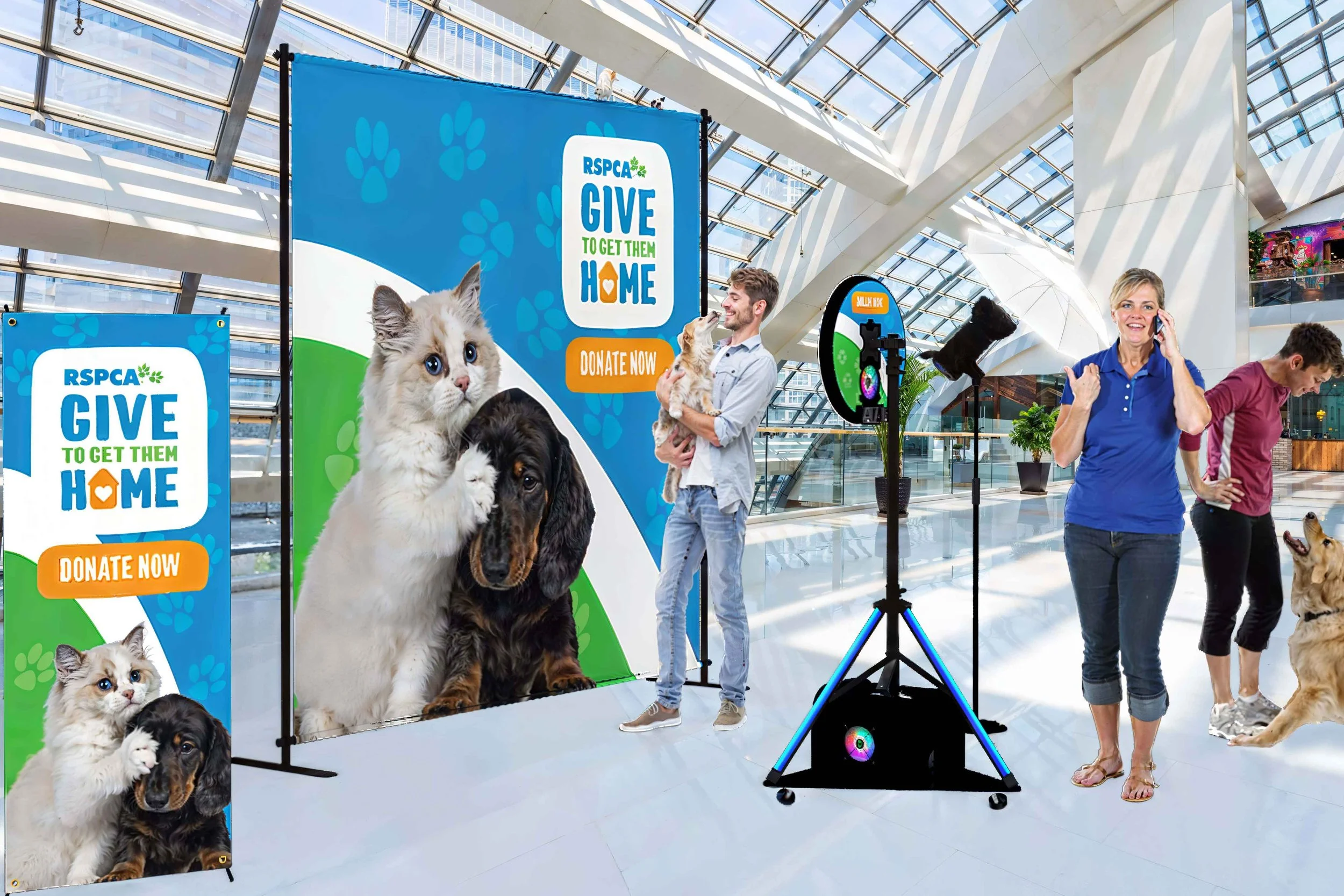 Candid event photography in Darwin showing families interacting with dogs and cats in front of professional RSPCA donation banners.