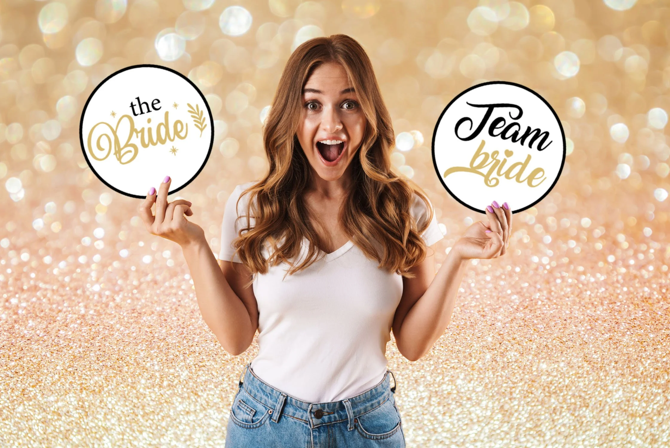 A woman with long brown hair holding signs that say "the bride" and "team bride" on a glittery, bokeh background