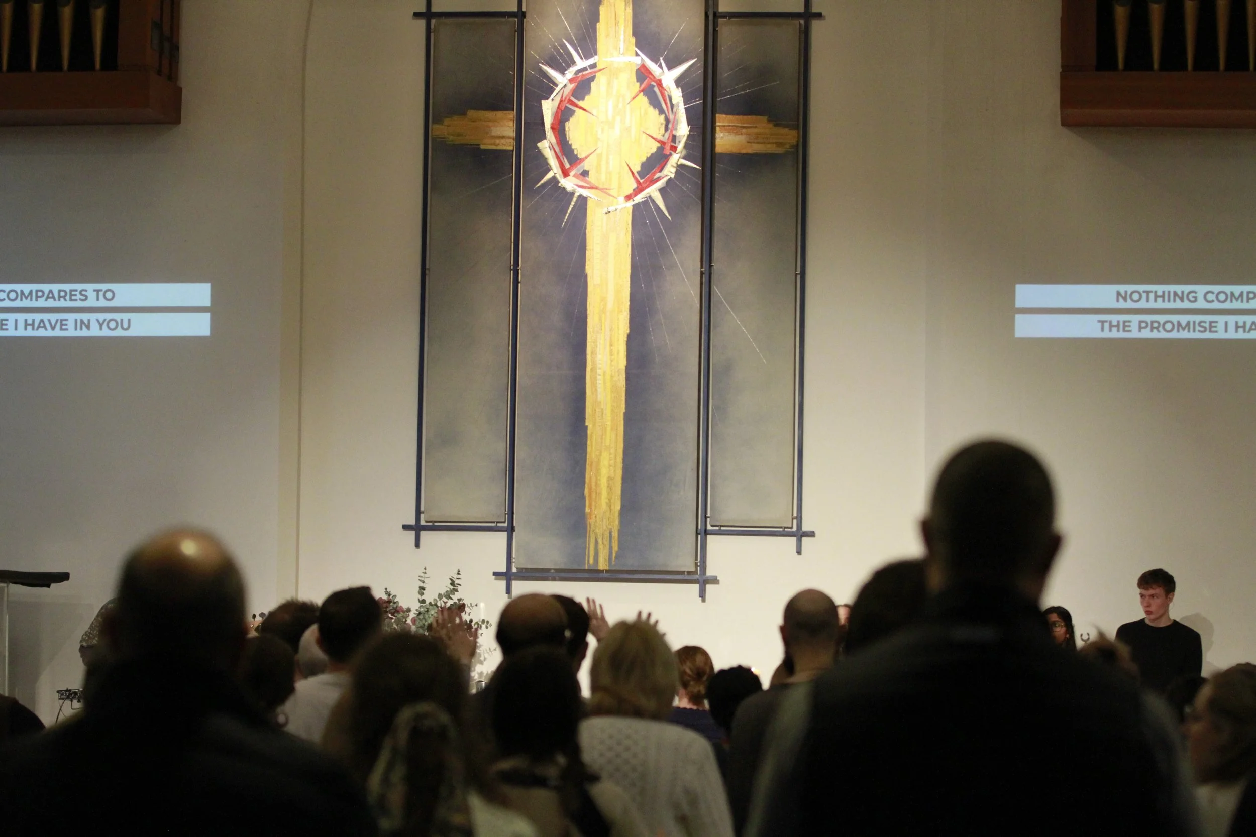 Image of a crowd of people at church worshipping and singing together.