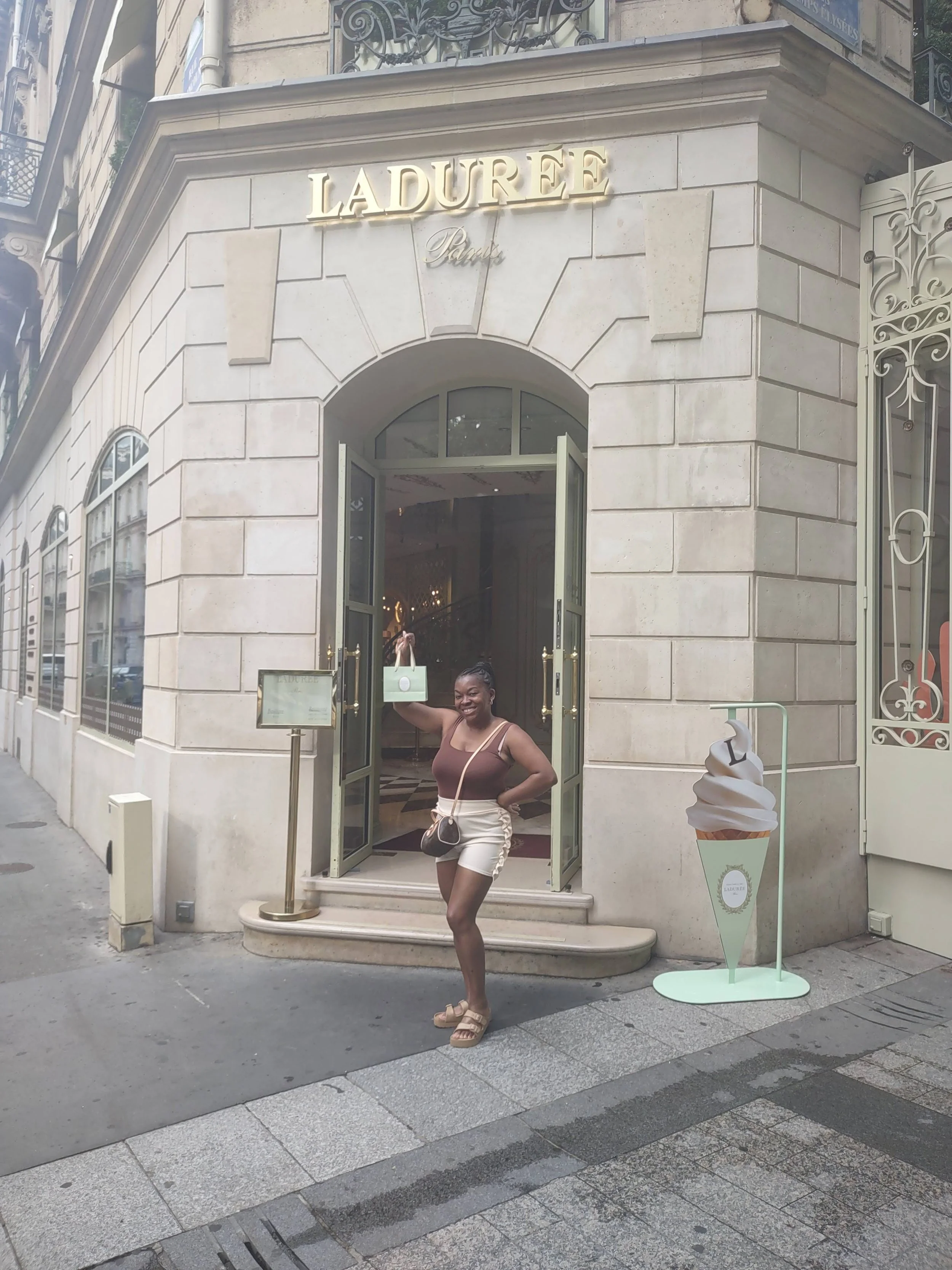 Woman standing in front of a the Laduree Macaron boutique.