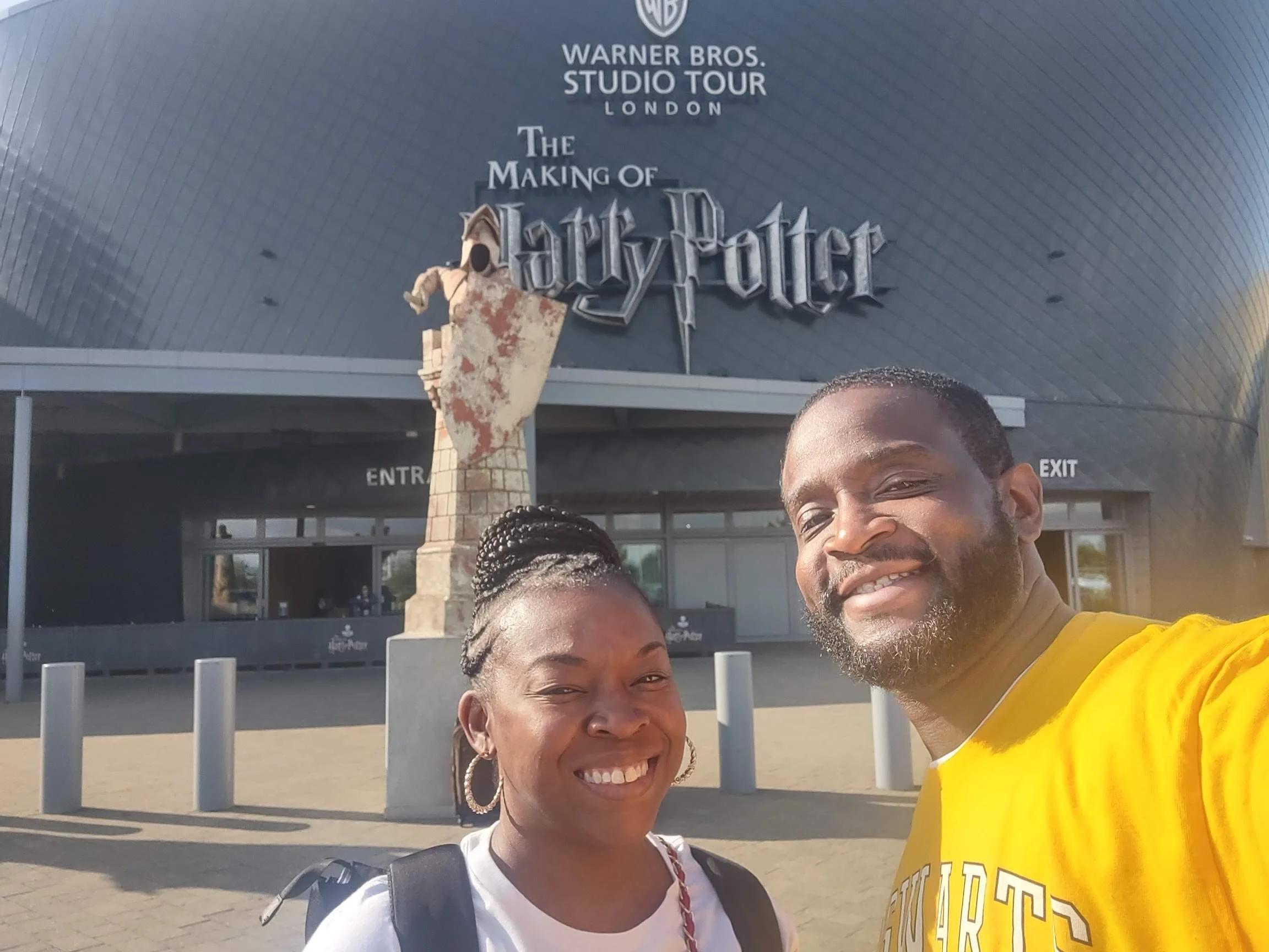A couple standing in front of the Warner Brothers Harry Potter Studio in London.