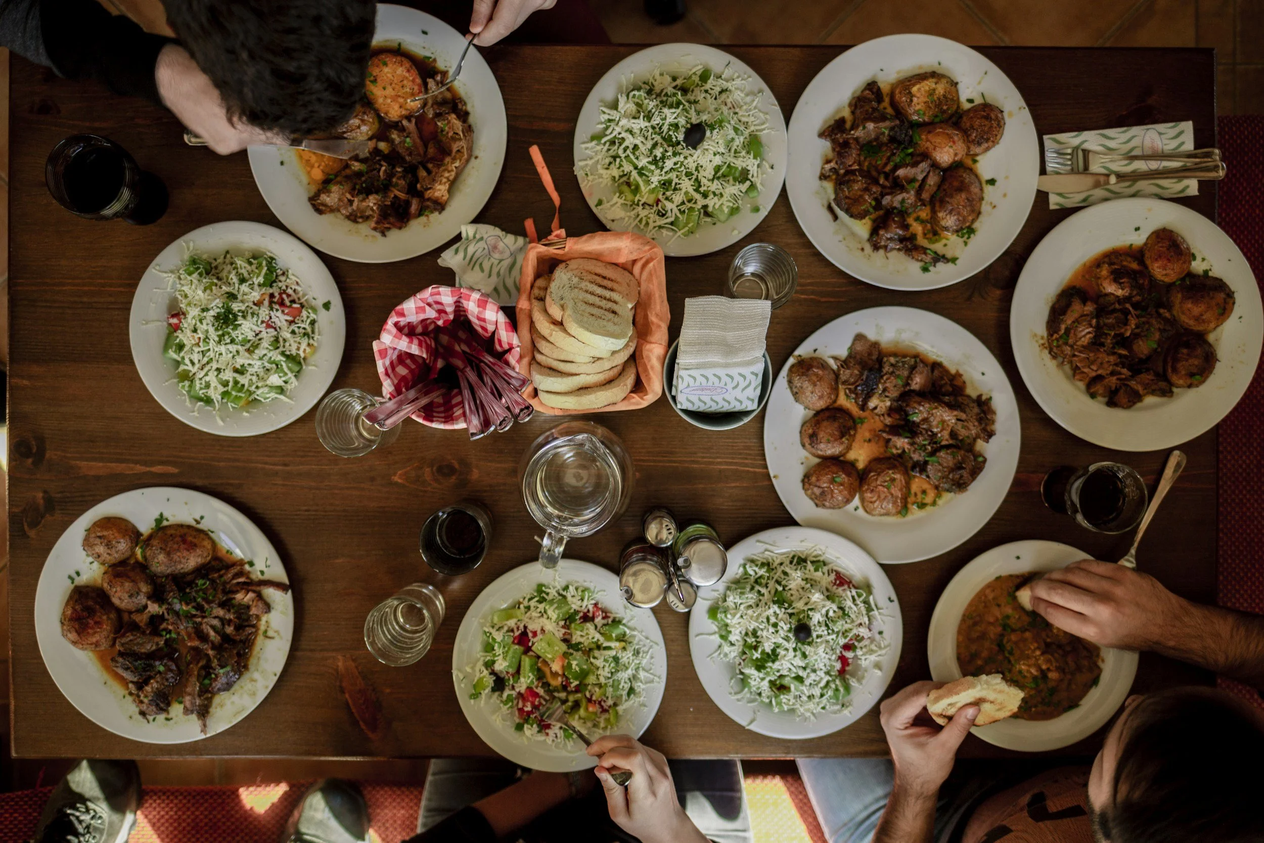 birds-eye-view of a crowded dinner table, several plates full of food