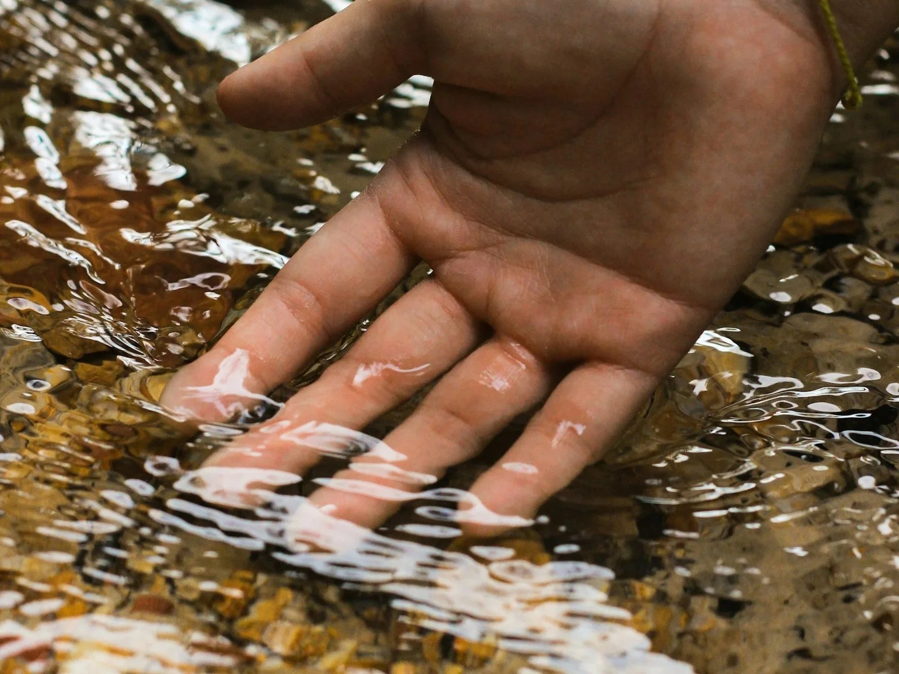 Five women sitting in chairs in a circle, engaged in a discussion, holding papers and taking notes in a room with beige walls and wooden doors.