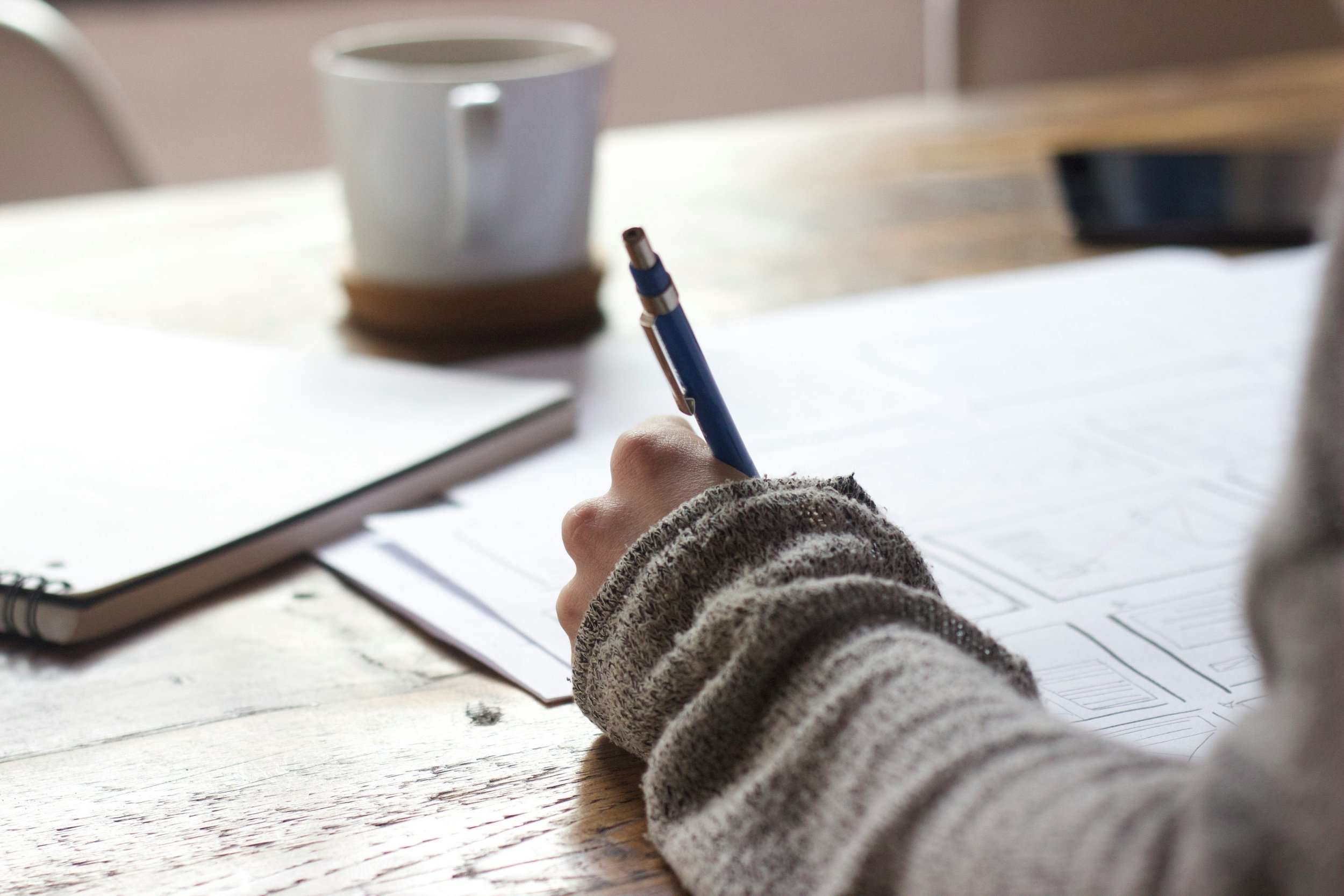 A pen in a hand, blurred white background