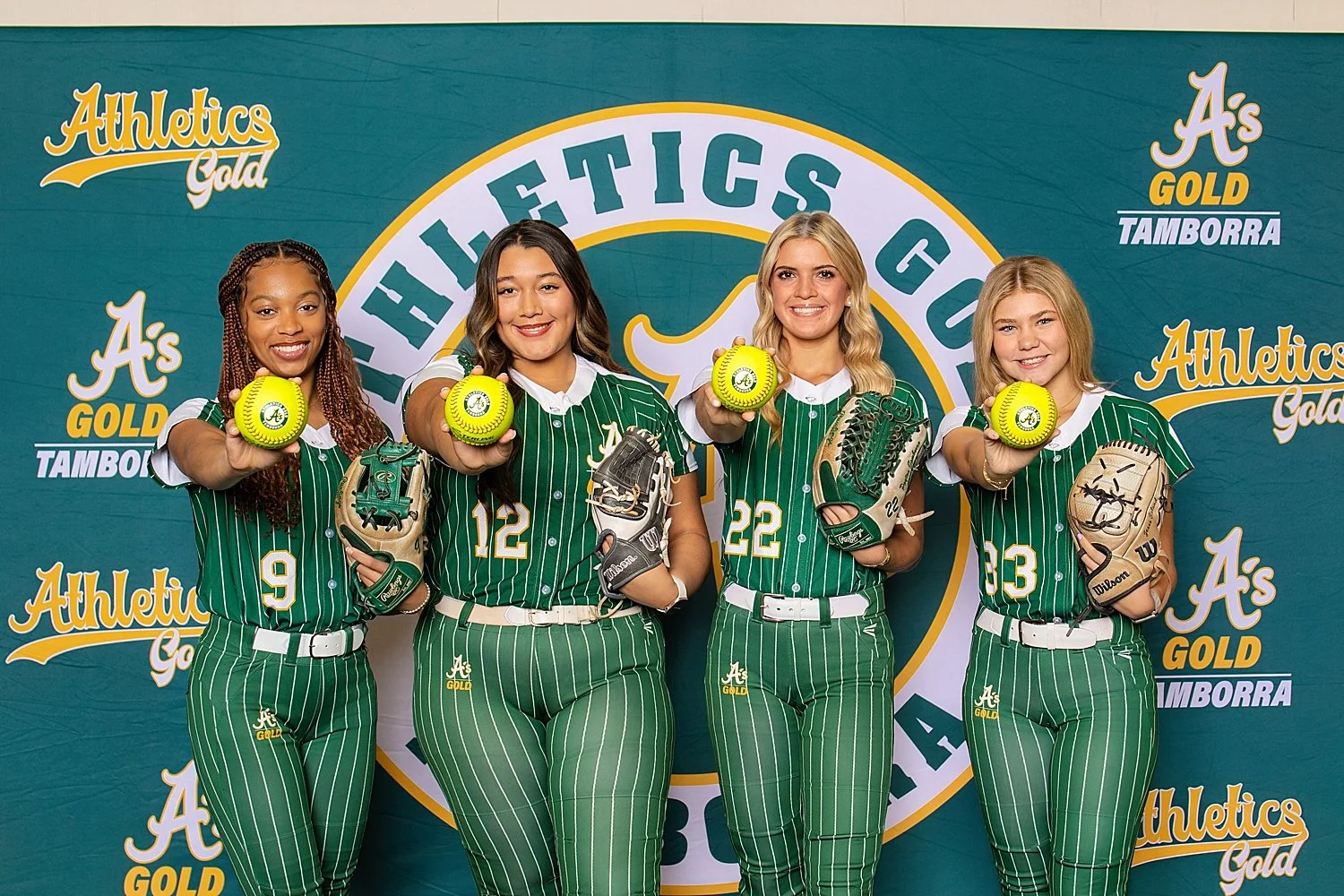 softball team stands in front of their banner showing daughters in sports