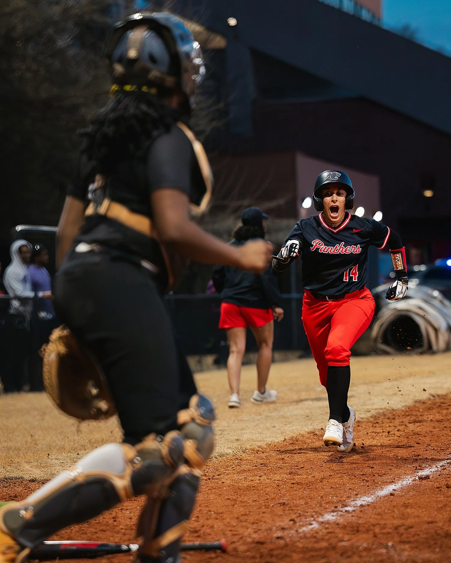  team member runs towards home plate on travel softball teams 