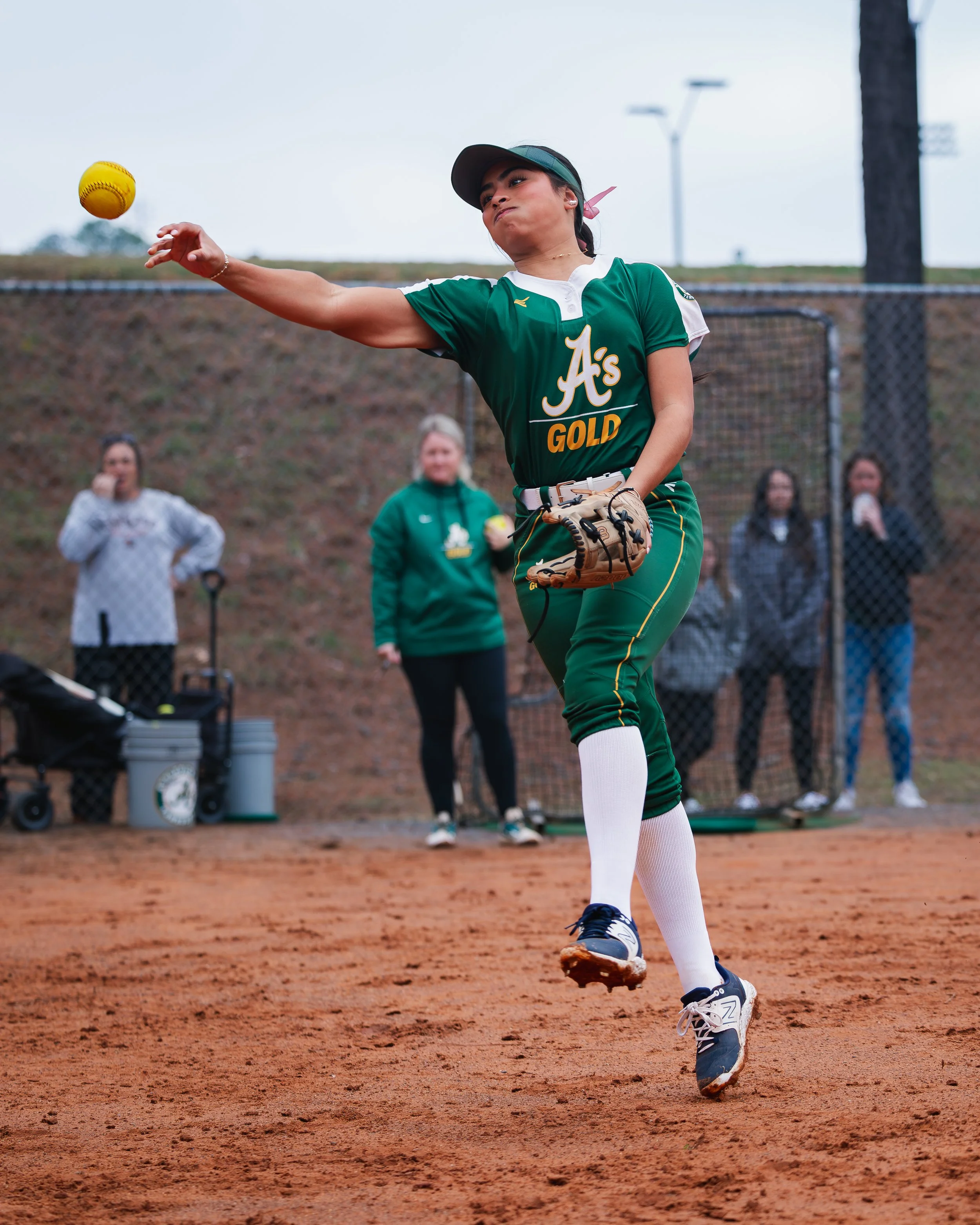  woman in green uniform catches softball by Tiaras Monet Photography 