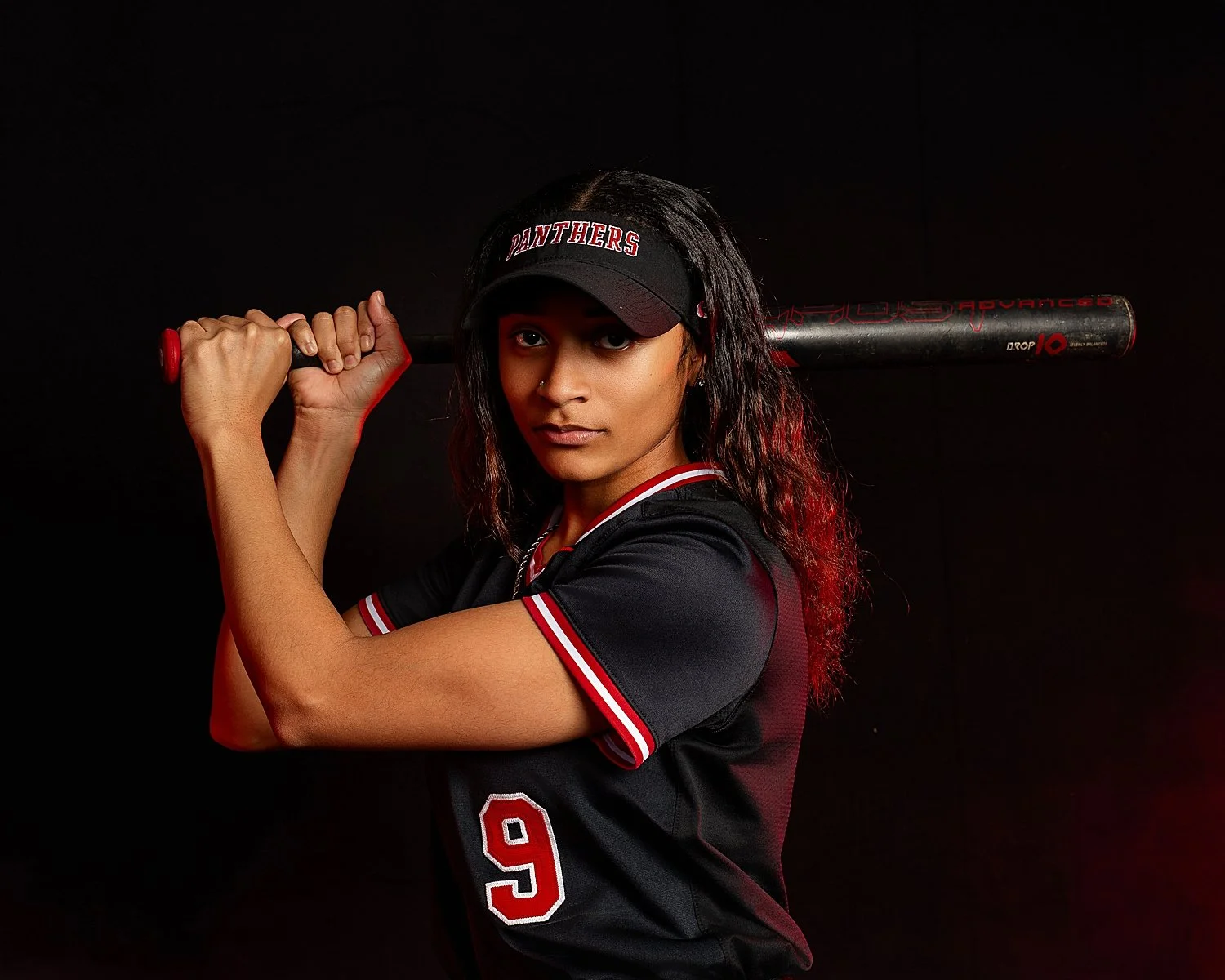  woman holds baseball bat behind her by Tiaras Monet Photography 