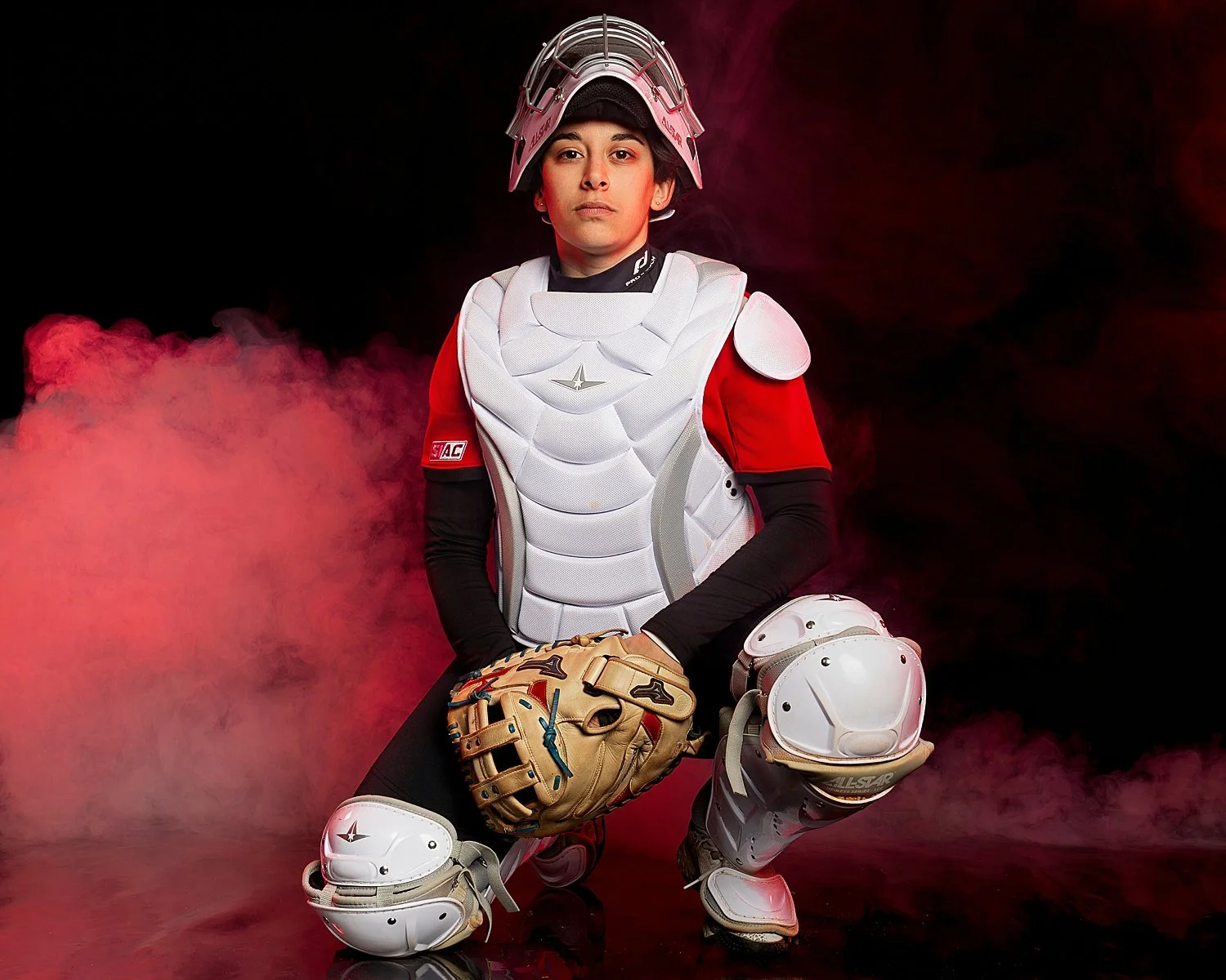  softball pitcher kneels in studio for portraits by Tiaras Monet Photography 