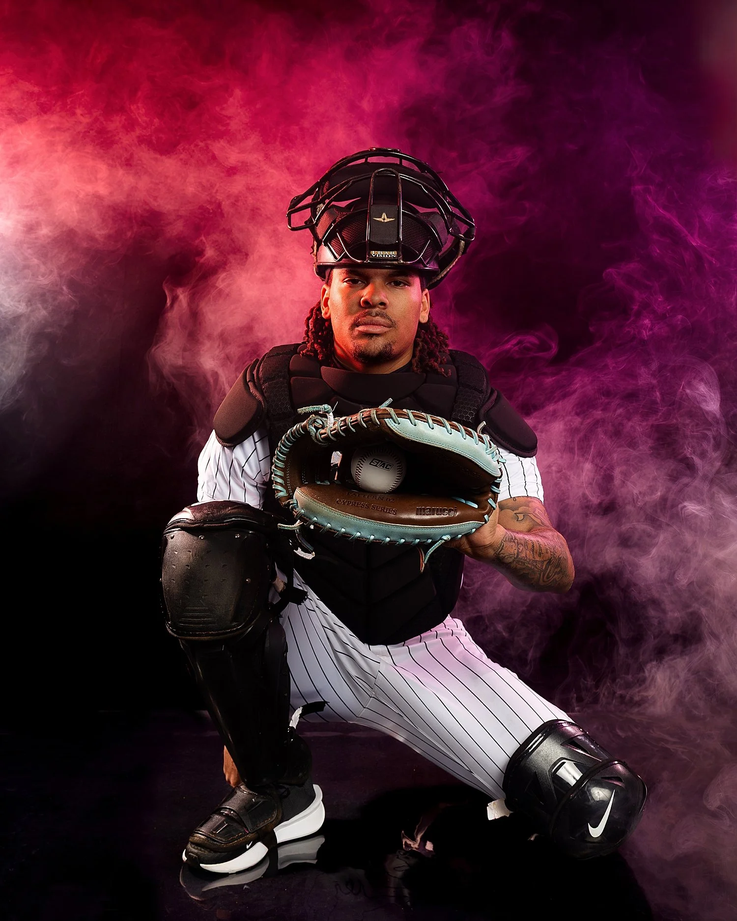  pitcher kneels in studio with smoke around for a media day 