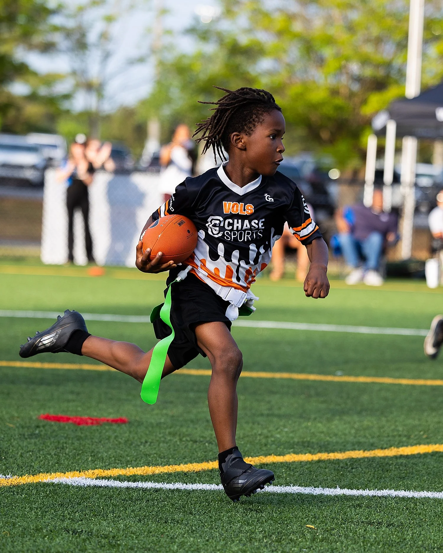  boy running on flag football field by Tiaras Monet Photography 