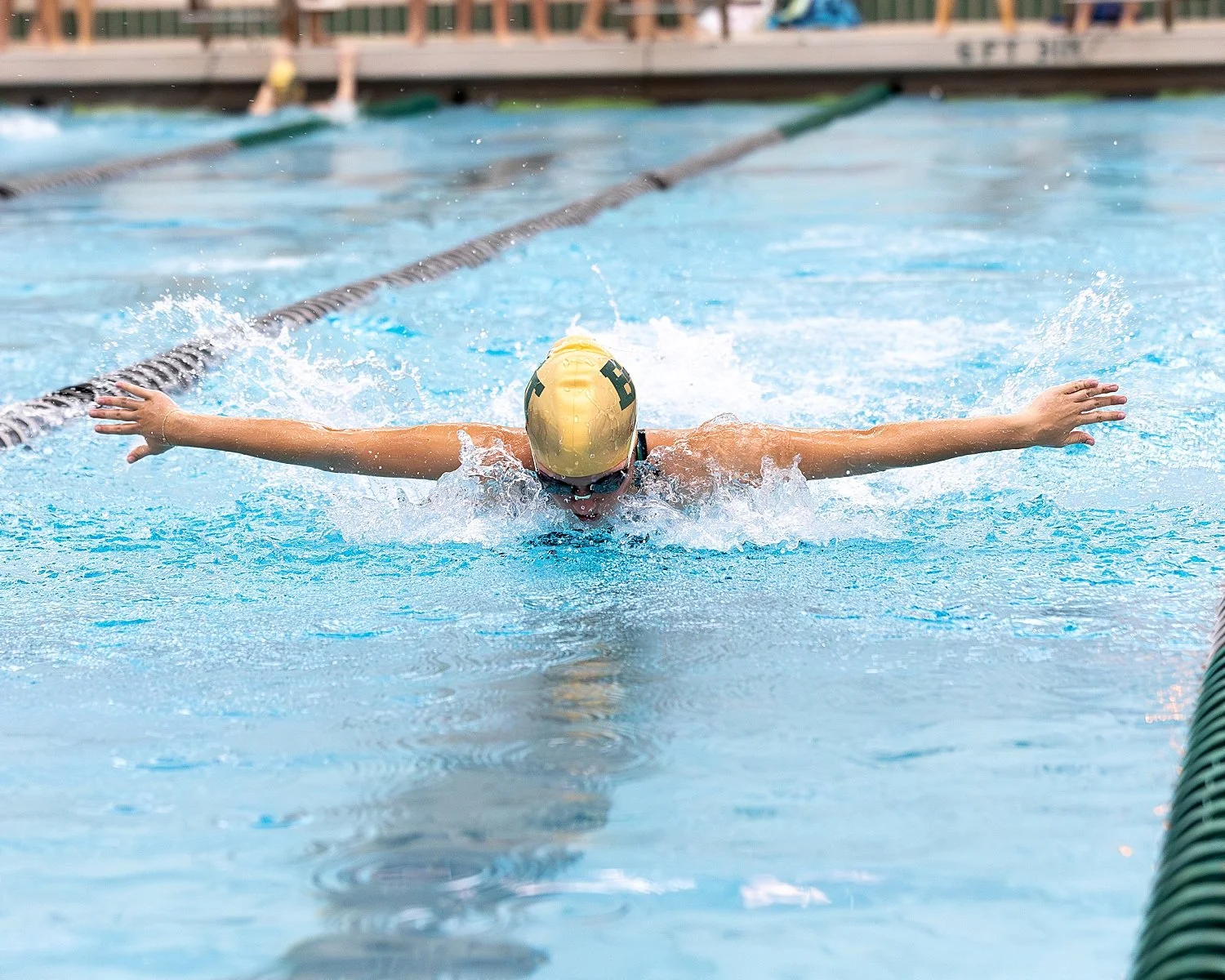swimmer races butterfly down a lane after building her preseason photography checklist