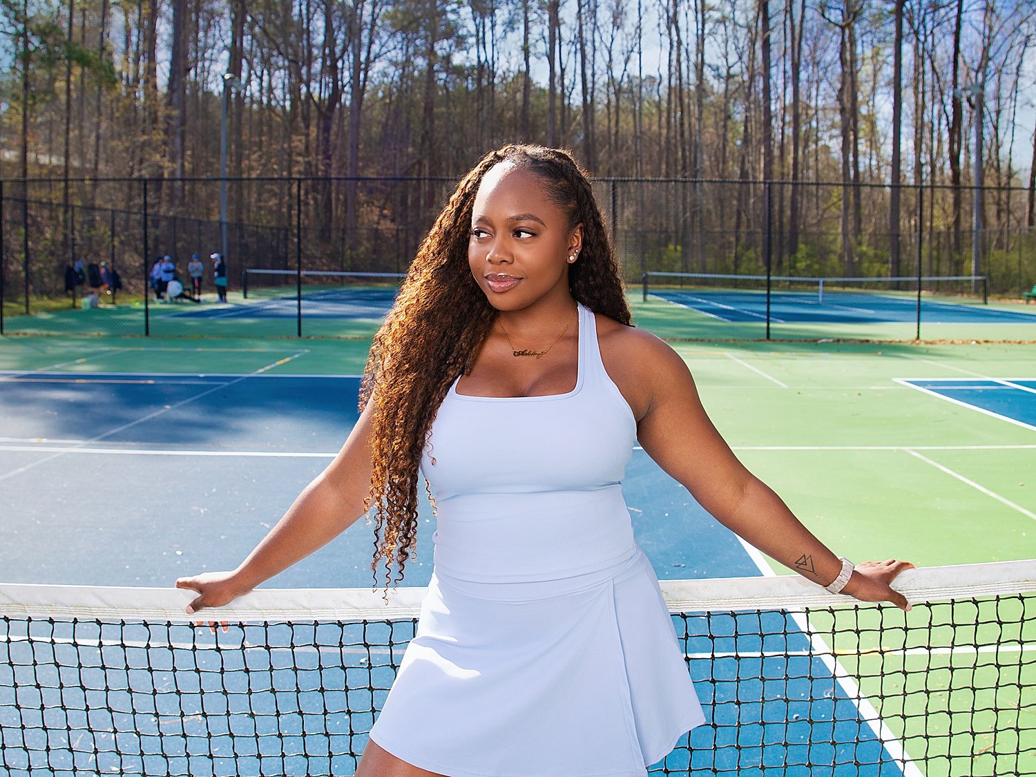 tennis player leans against net showing daughters in sports