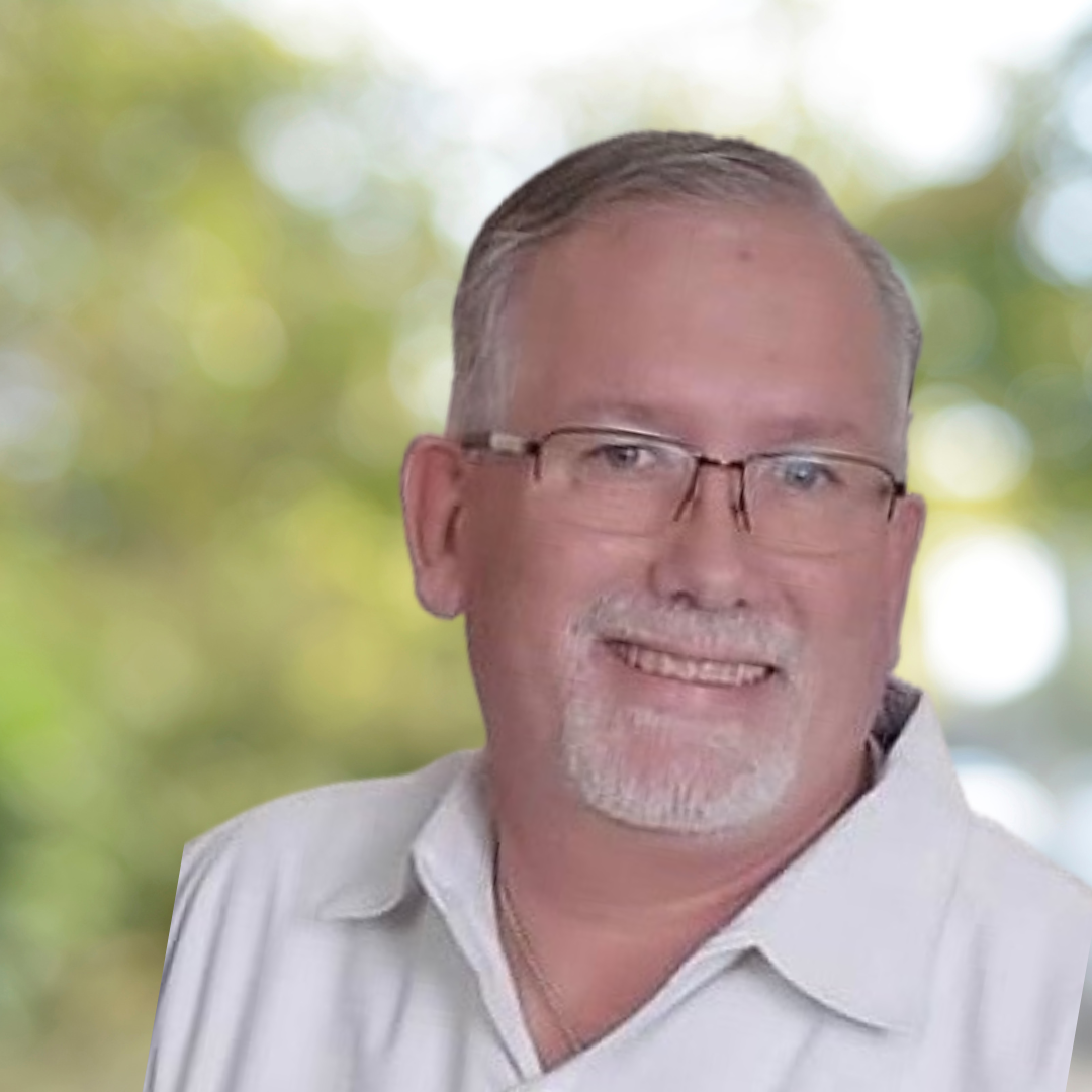 Portrait of Chad Jolley, counseling intern at Sanity Center, smiling and wearing glasses and a light-colored collared shirt.