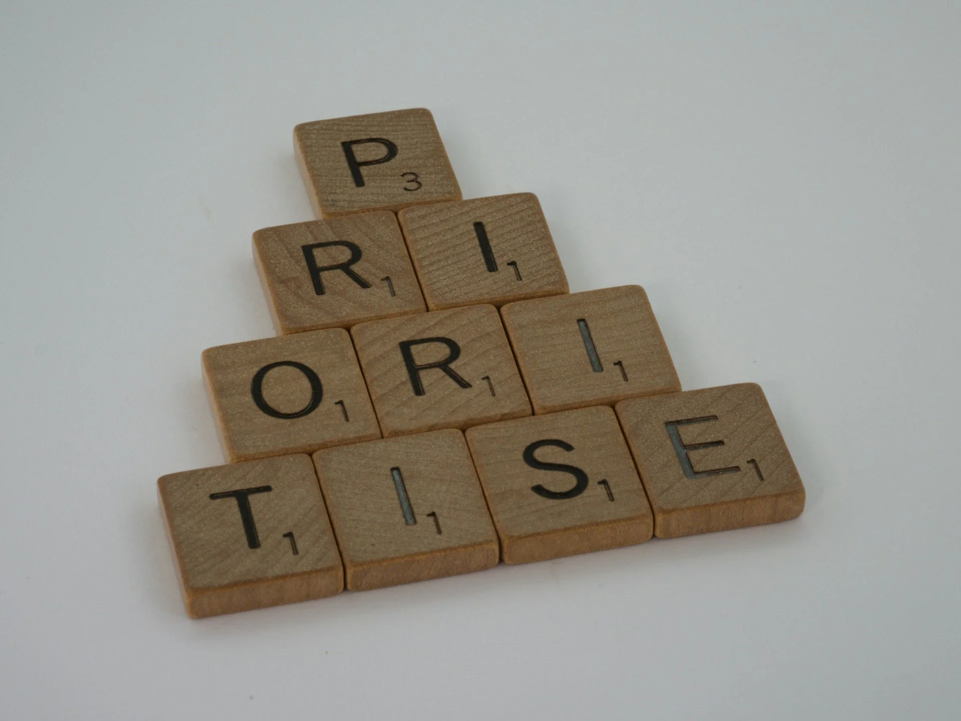 Scrabble letters merged to form the word PRIORITISE