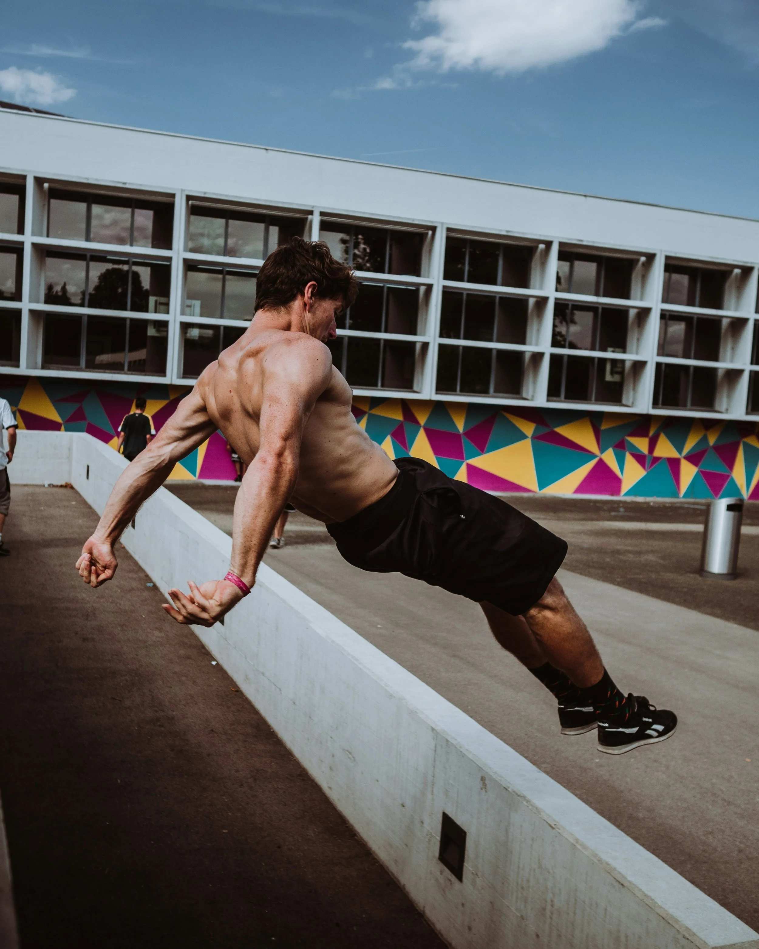 Man leaping with abdominals functioning as he jumps over a wall