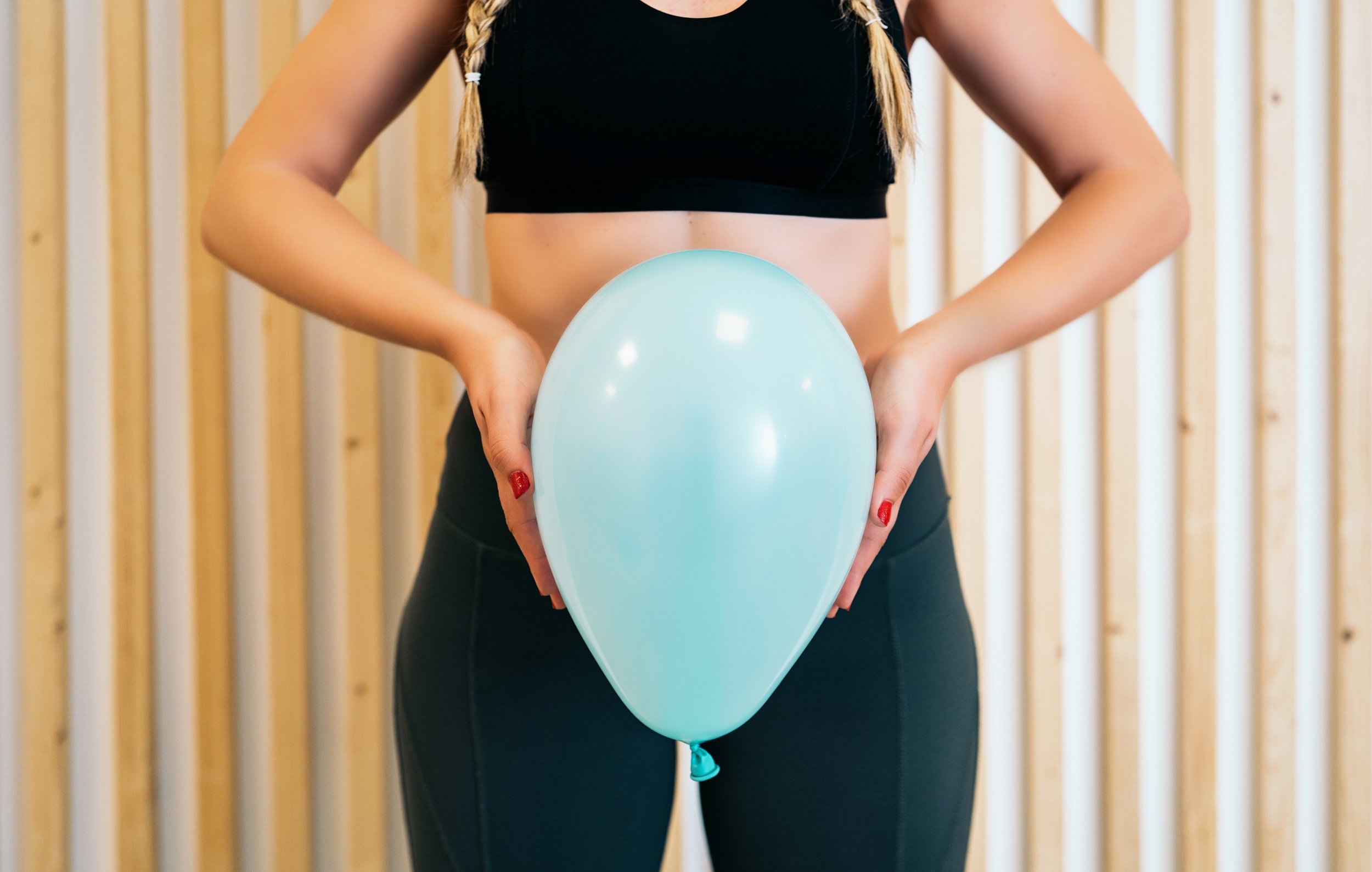 woman holding a balloon to show pelvic floor pressure