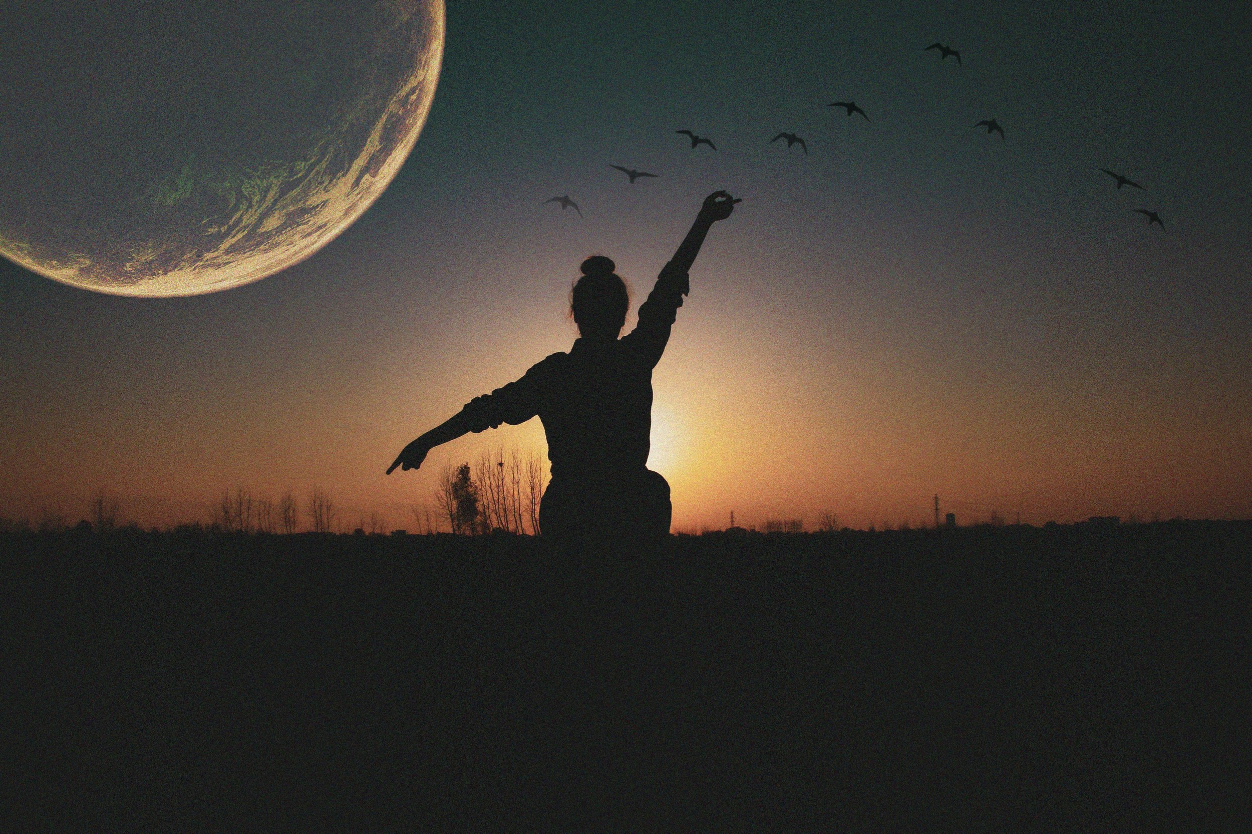 Woman sitting in hestia pose with geese flying over and the full moon hanging to the left