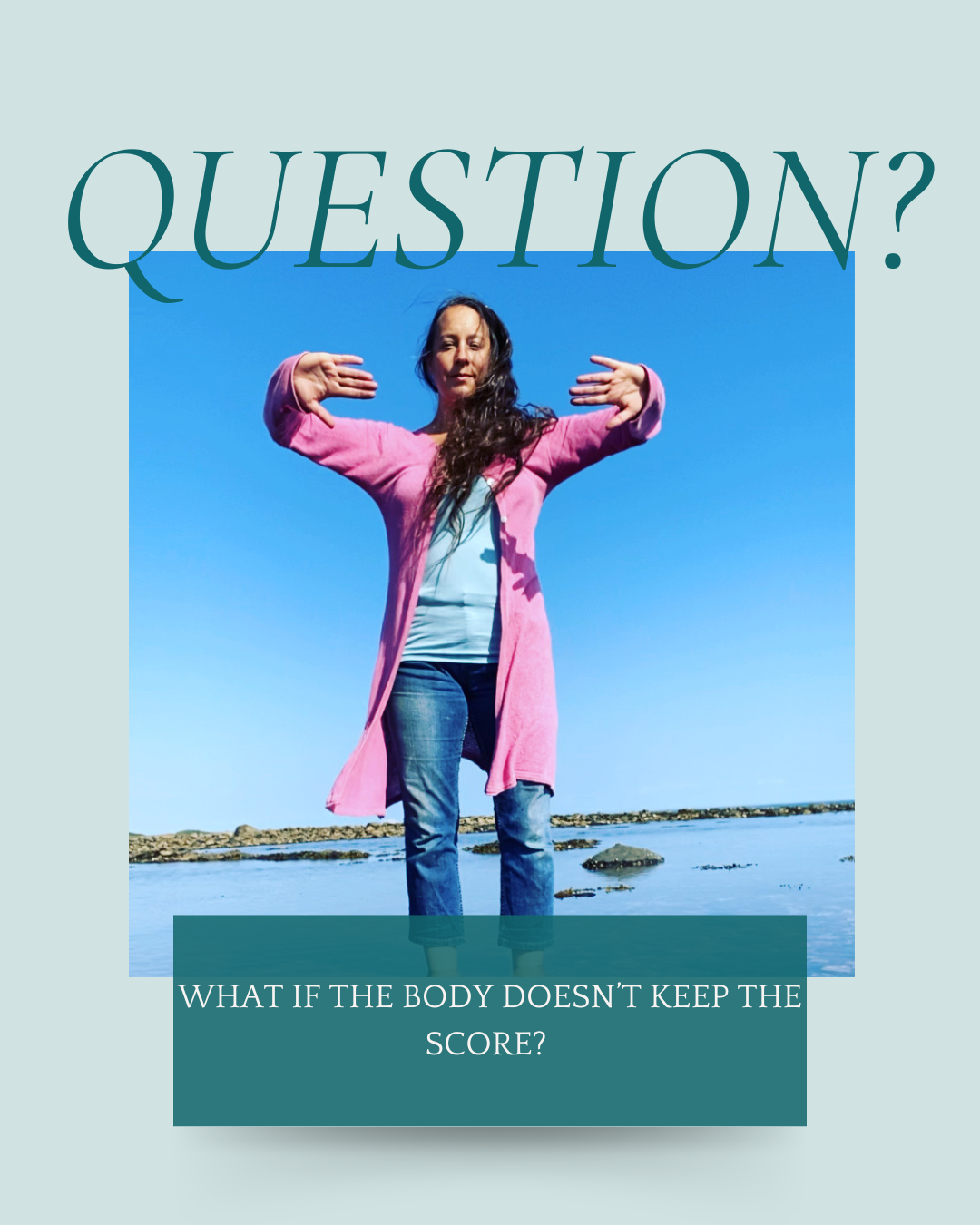 Abby standing in the sea, wearing jeans, a blue vest top and a pink open cardigan, it's a sunny day