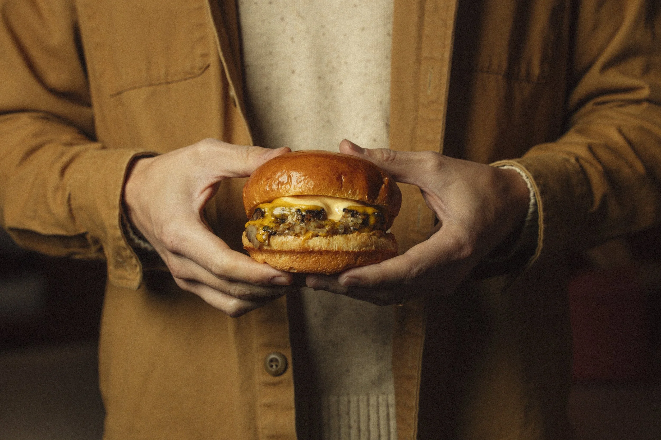 Woman holding cheeseburger