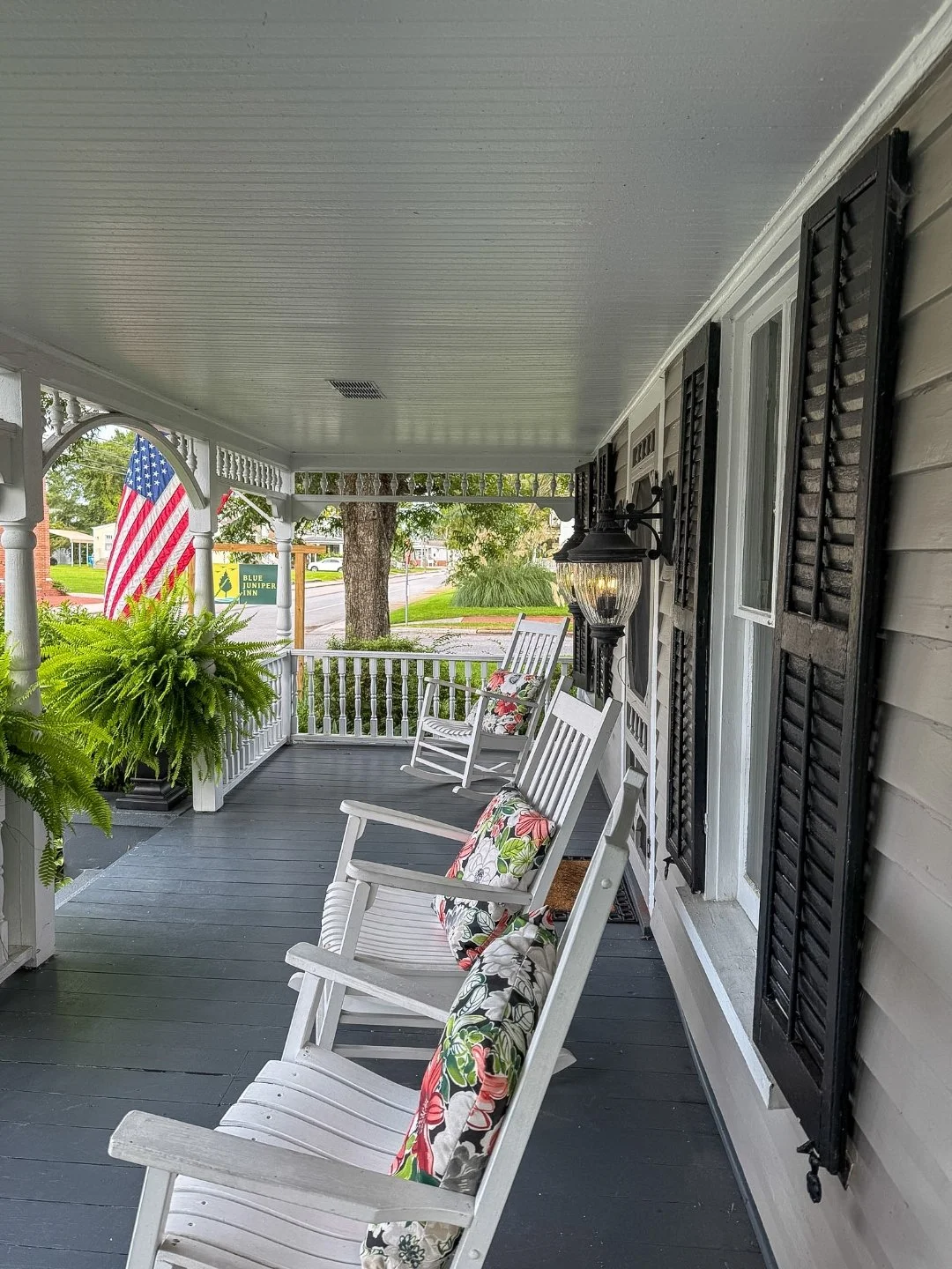 The front porch rocking chairs at Blue Juniper Inn with the American flag in the background