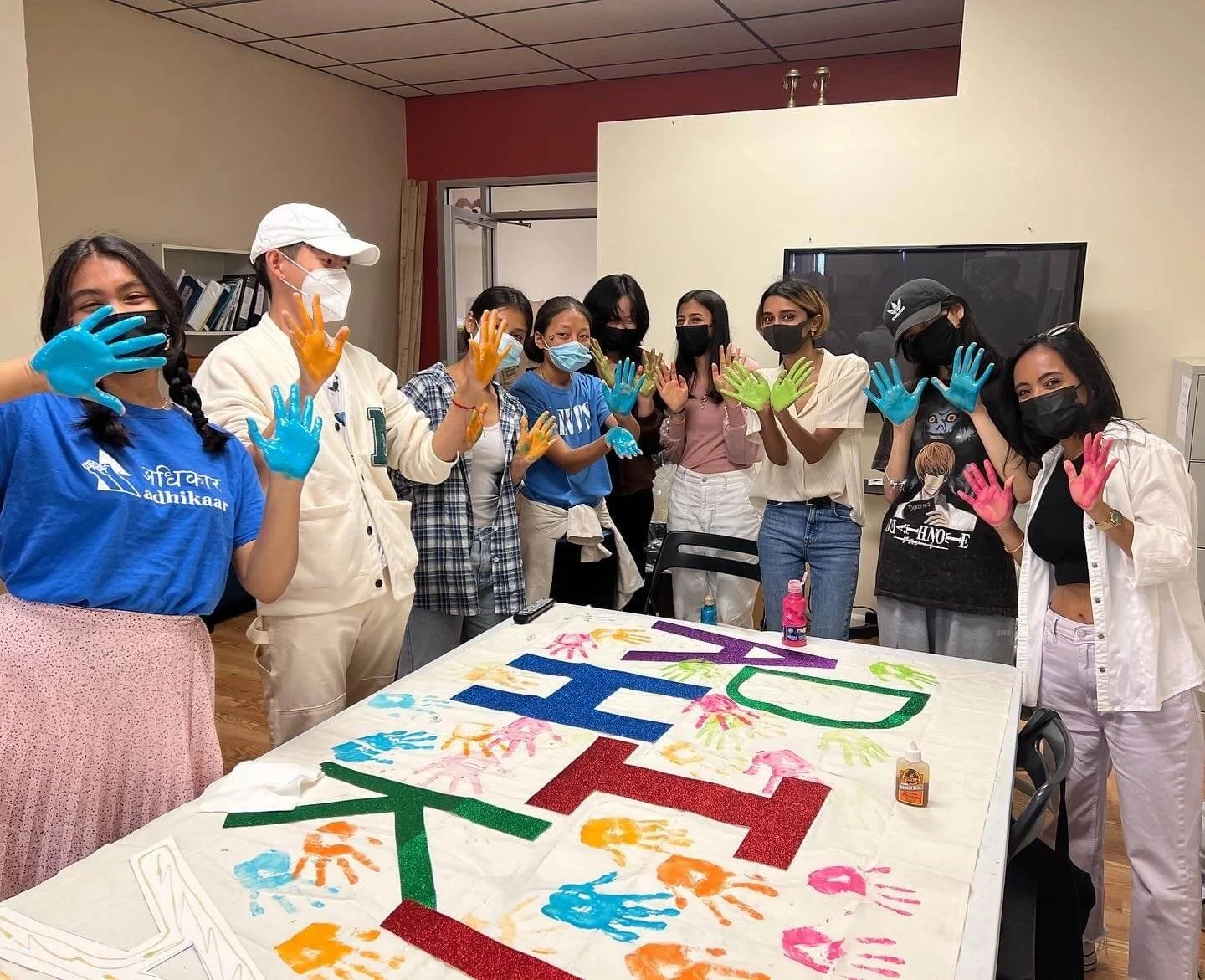Our youth members painting a banner for our annual Queens Pride march.
