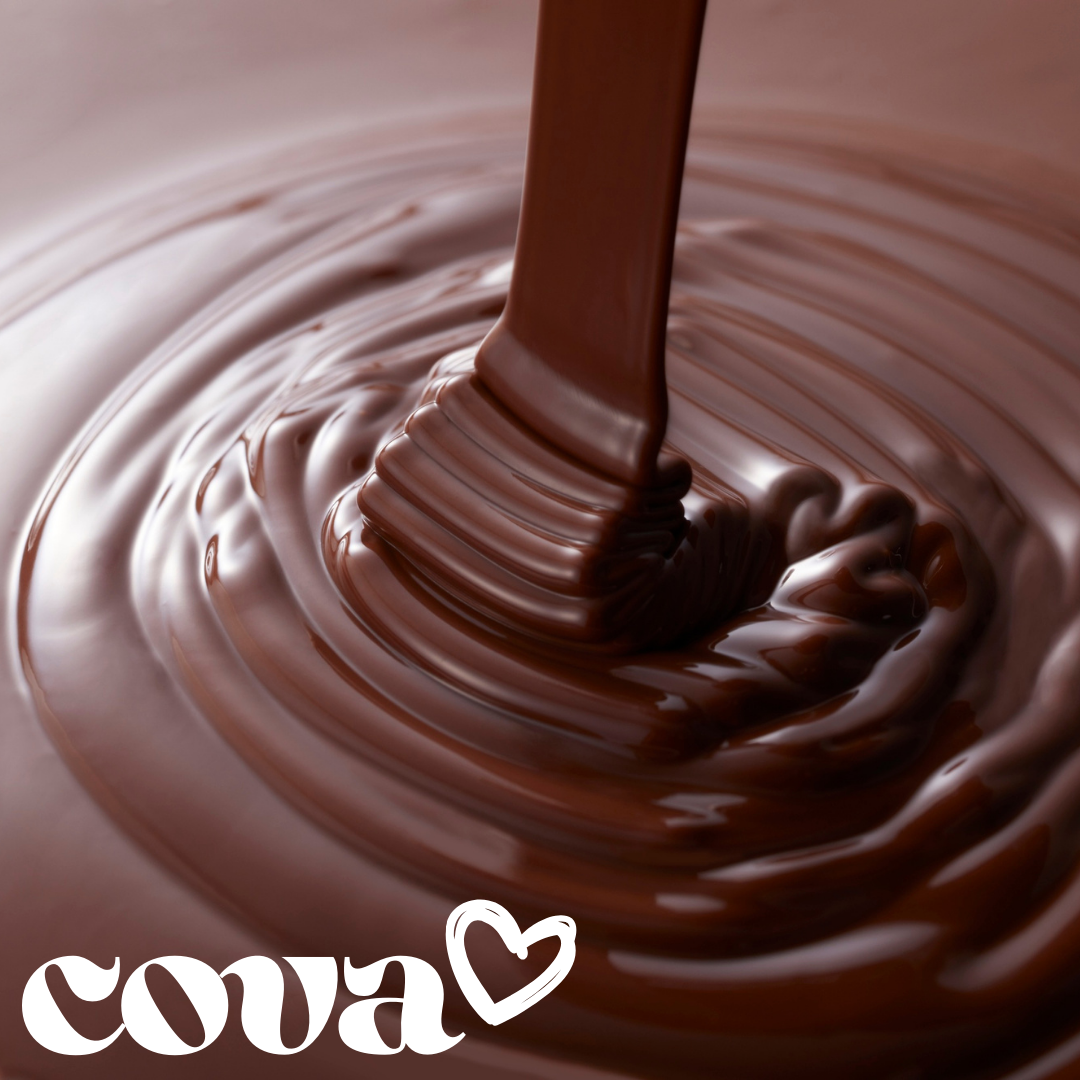 Close-up of melted chocolate being poured and swirling in a bowl.