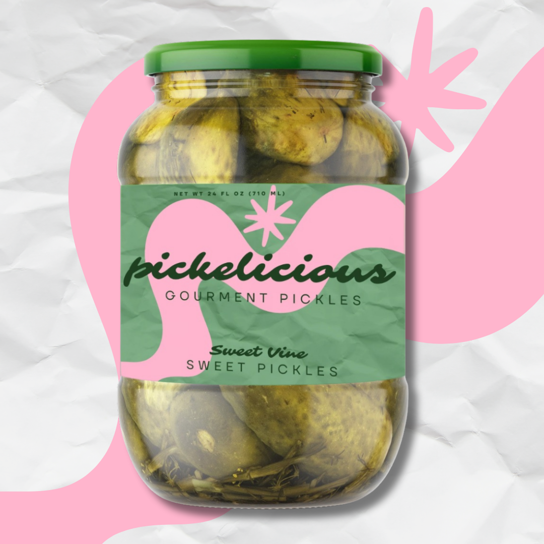 A glass jar of Pickleicious gourmet sweet pickles with a green lid and label, set against a pink and white abstract background.