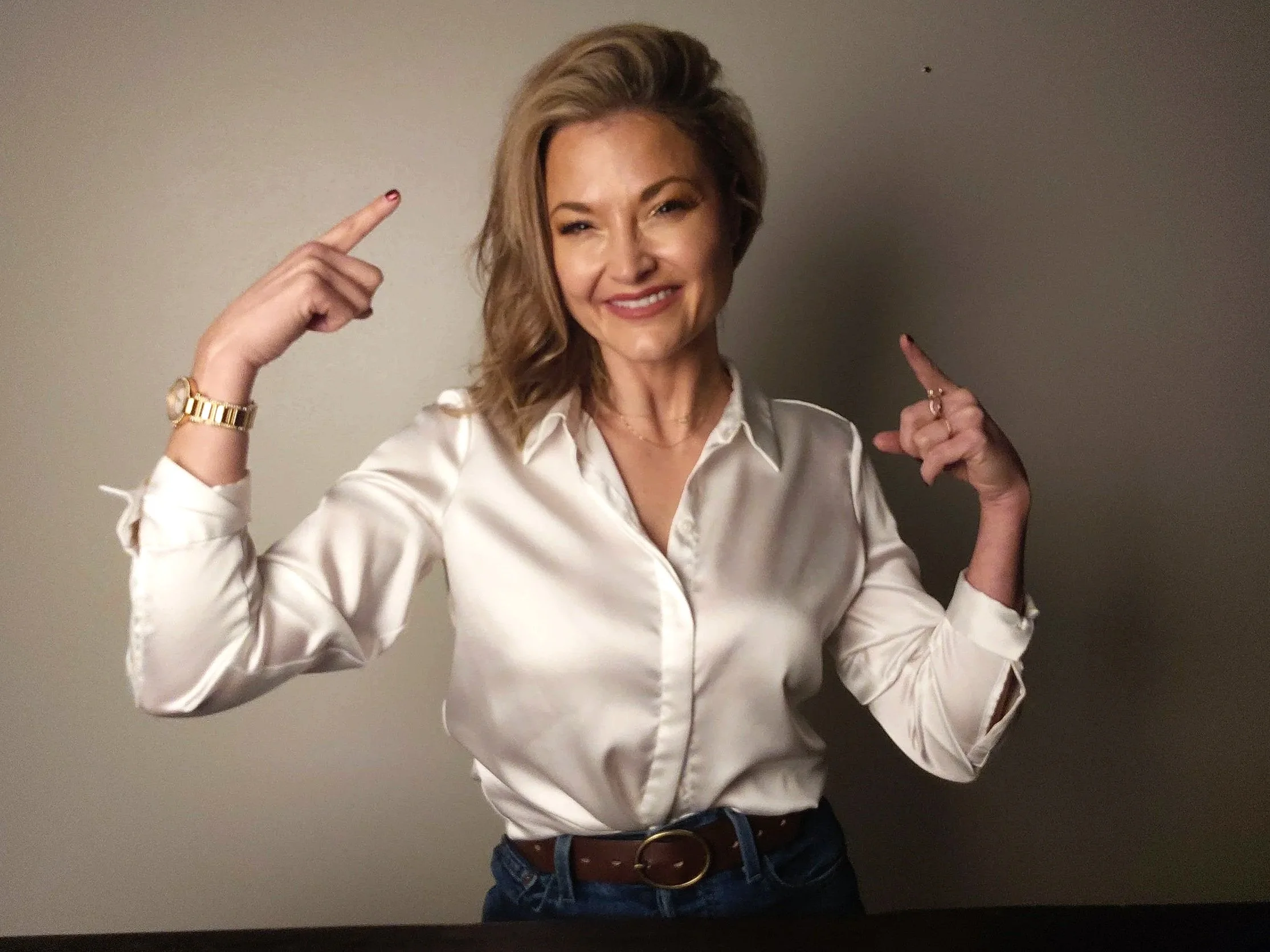 Elevate Mindworks hypnosis practitioner pointing toward her head for guided hypnosis, mind relief, overthinking support, inner pressure, and helping high-functioning adults make their mind their ally.