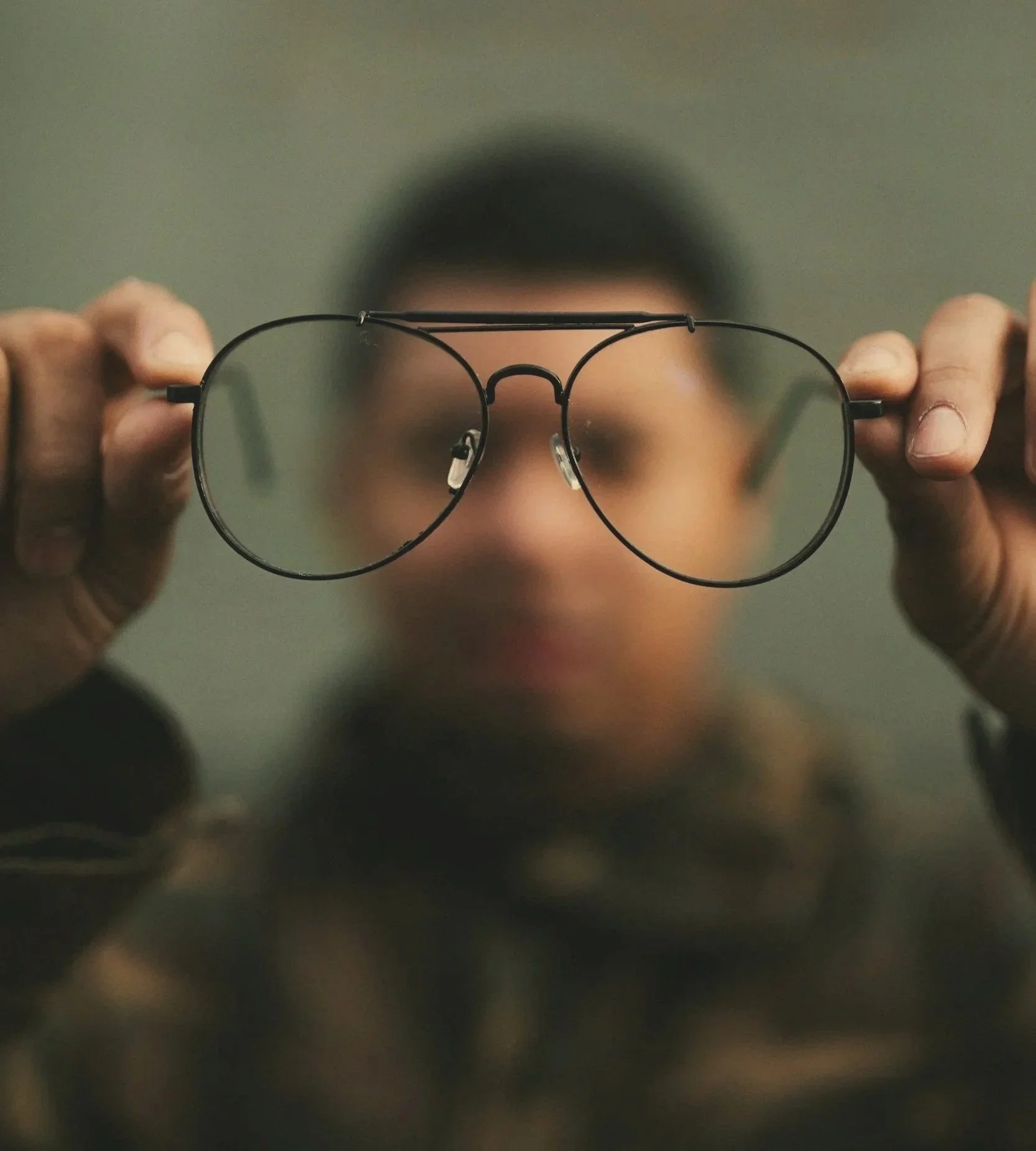 A man holding his glasses and concentrating, representing focus, clarity, and mental reset with Elevate Mindworks guided support