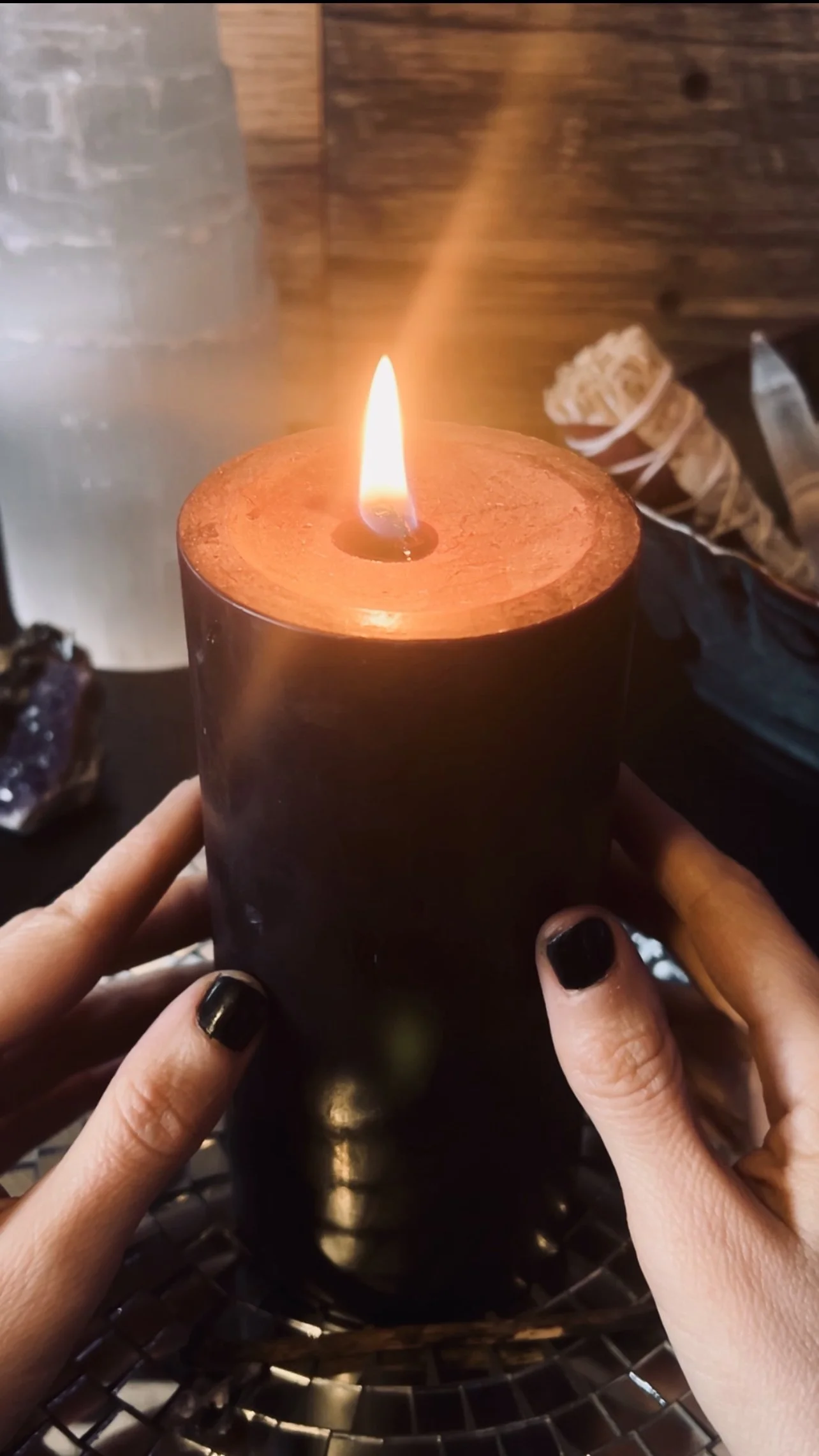 Selene Awen holding a ritual candle during a grounding meditation for energy clearing