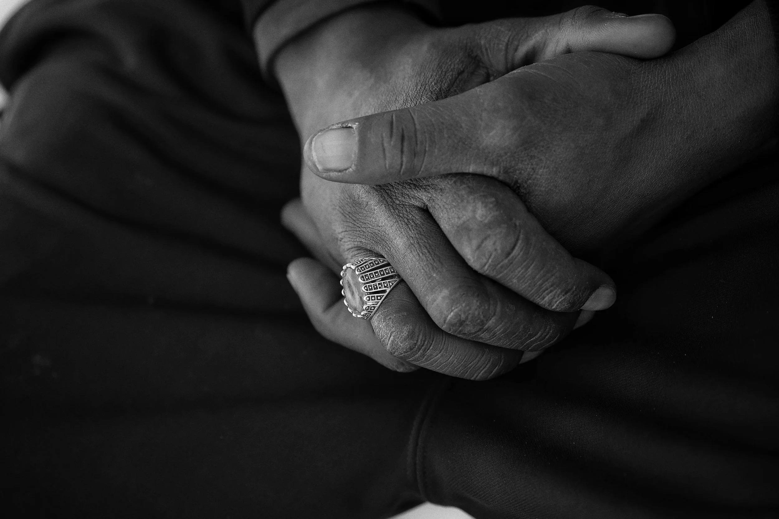 Close up of folded hands in black and white, representing grief stored in the body and nervous system