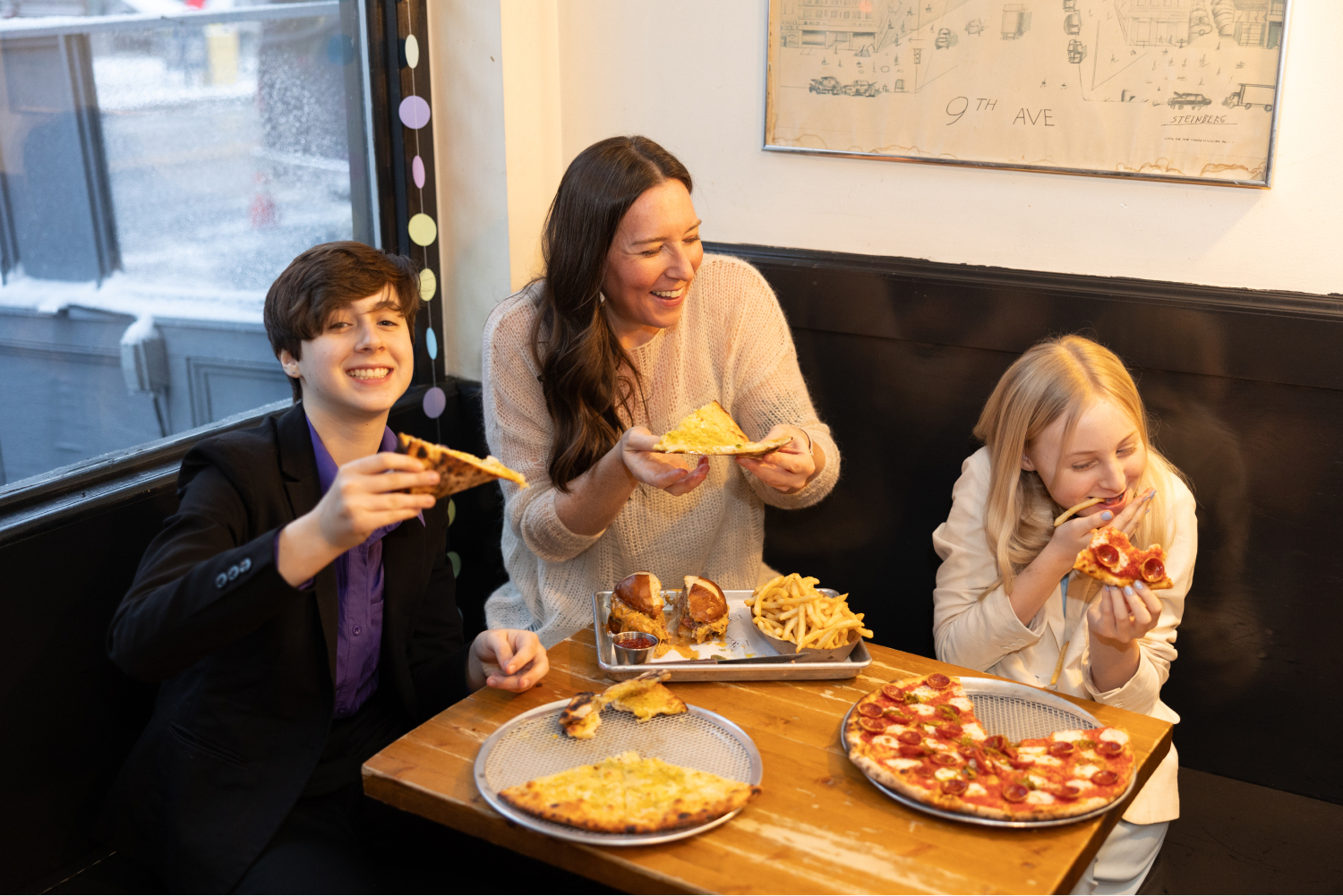 Emily Hyland at Emily Loves Pizza with two kids enjoying detroit style pizza and the Emmy Burger