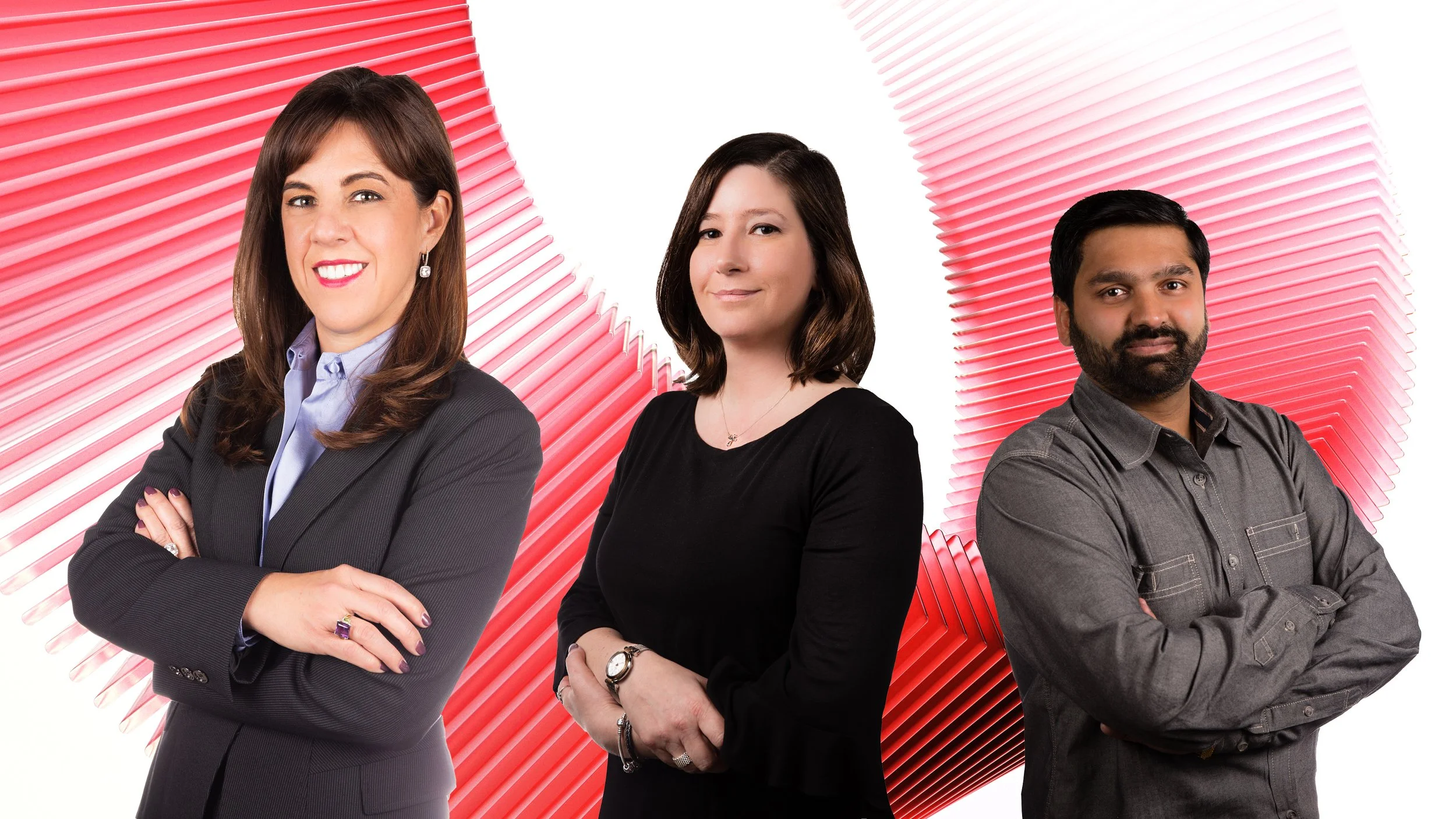 Three diverse professionals standing with arms crossed in front of a red and white abstract background.