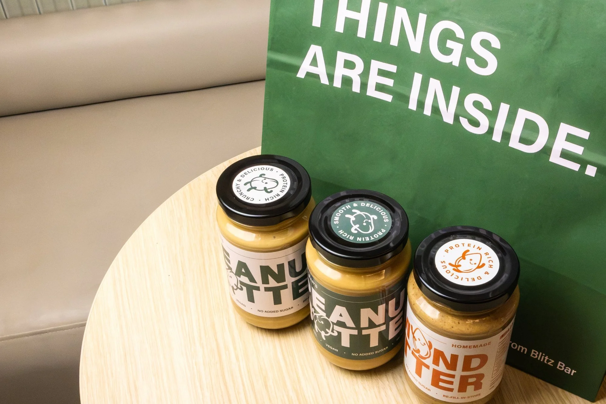 Blitz Bar crunchy peanut butter, smooth peanut butter and almond butter jars with a Blitz Bar takeaway bag
