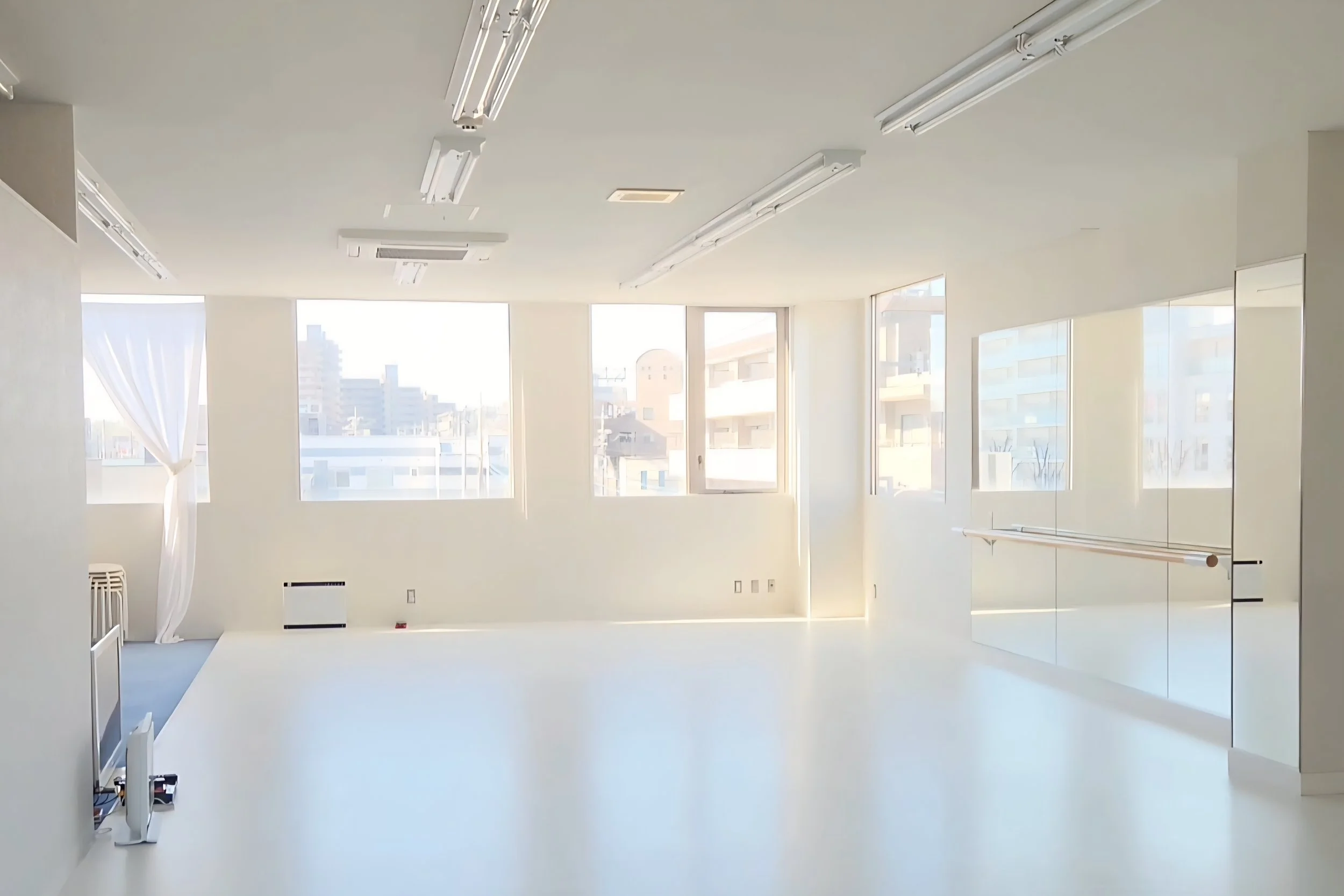 Lithe Life Studio. A large brightly lit studio with big windows and large mirrors