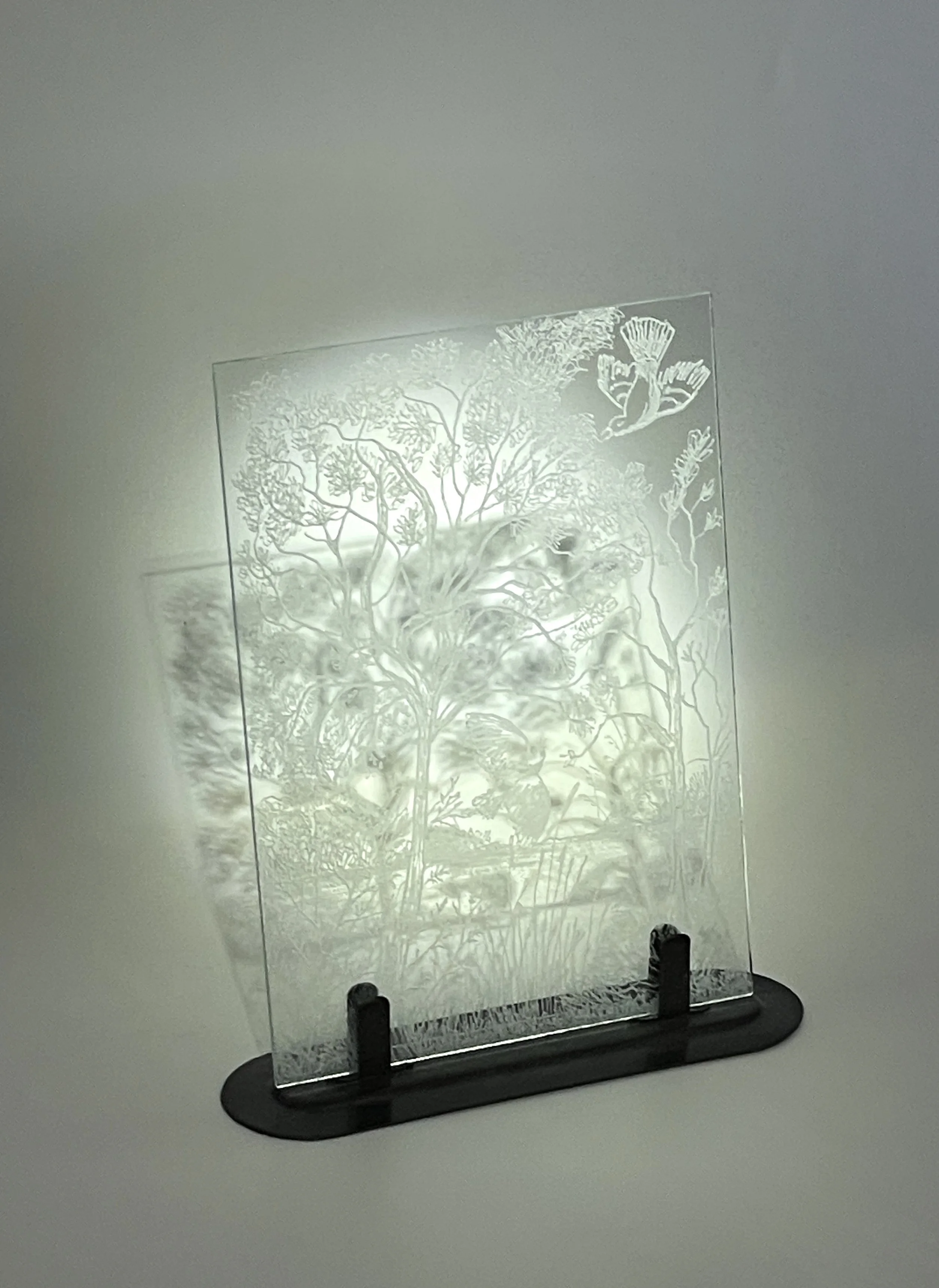 Etched glass panel on metal stand.
