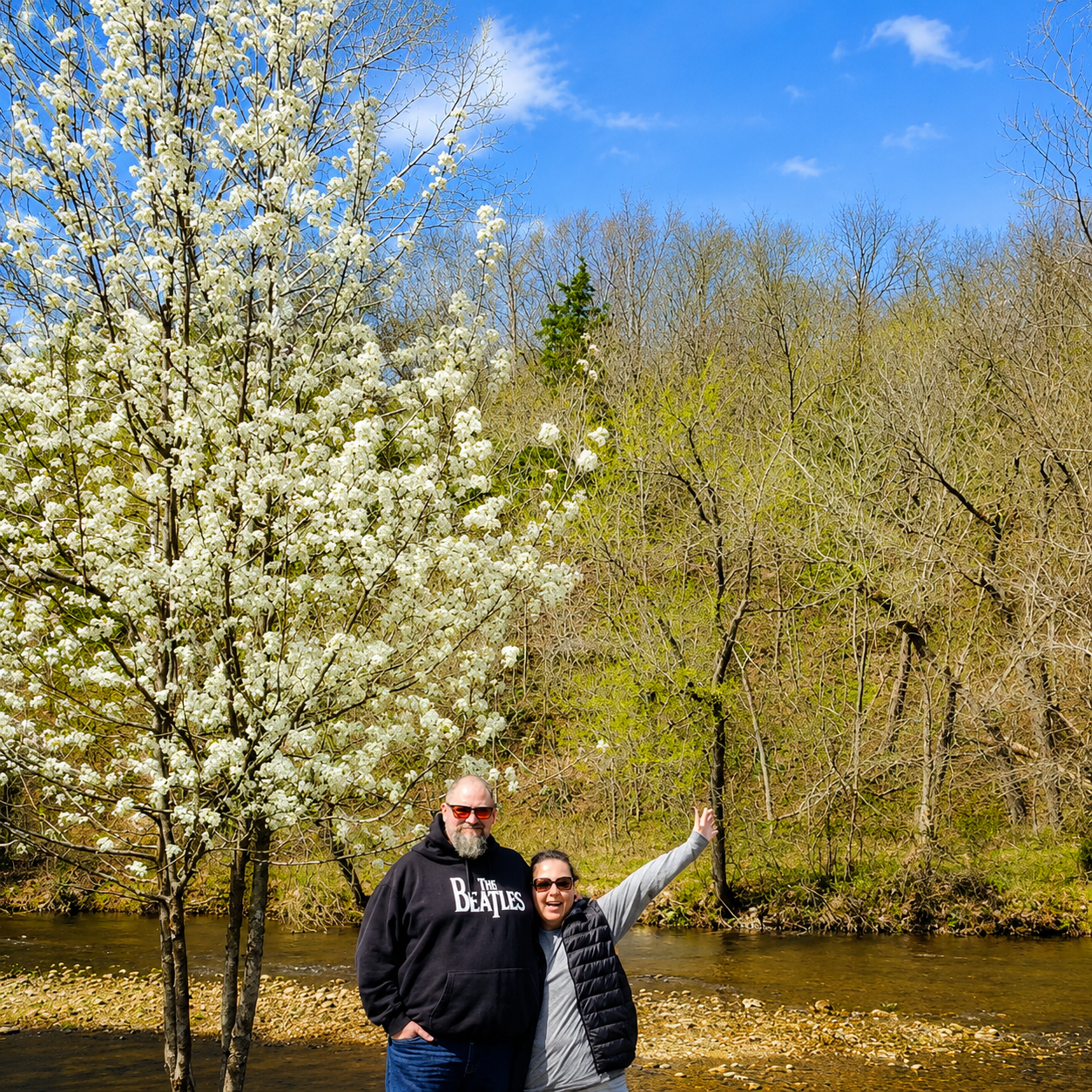 Camp Creekside owners Mahal and Levi standing beside the creek at their campground.