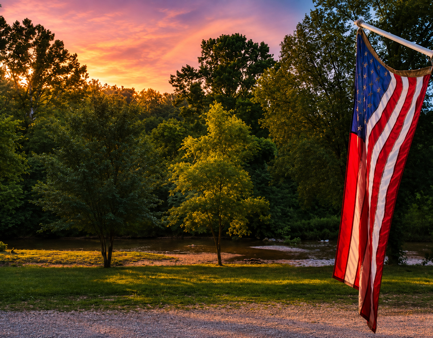 Sunset over the creek and campground at Camp Creekside in Gravois Mills, Missouri, with an American flag in the foreground.