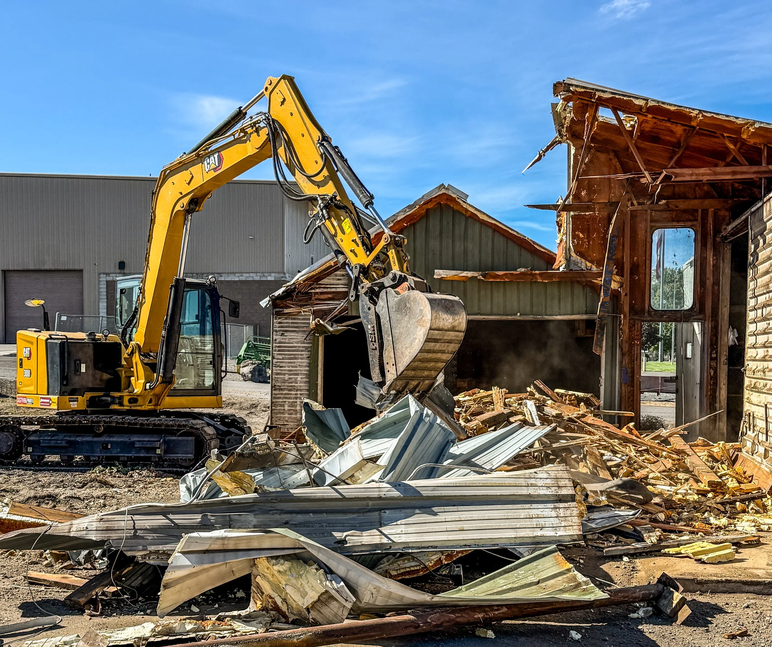 CAT excavator demolishing a large barn in Klamath Falls, Oregon