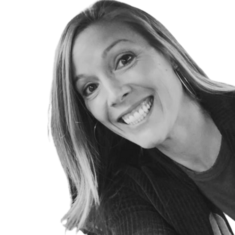 A woman with shoulder-length hair smiling and wearing hoop earrings, in a black-and-white photo.