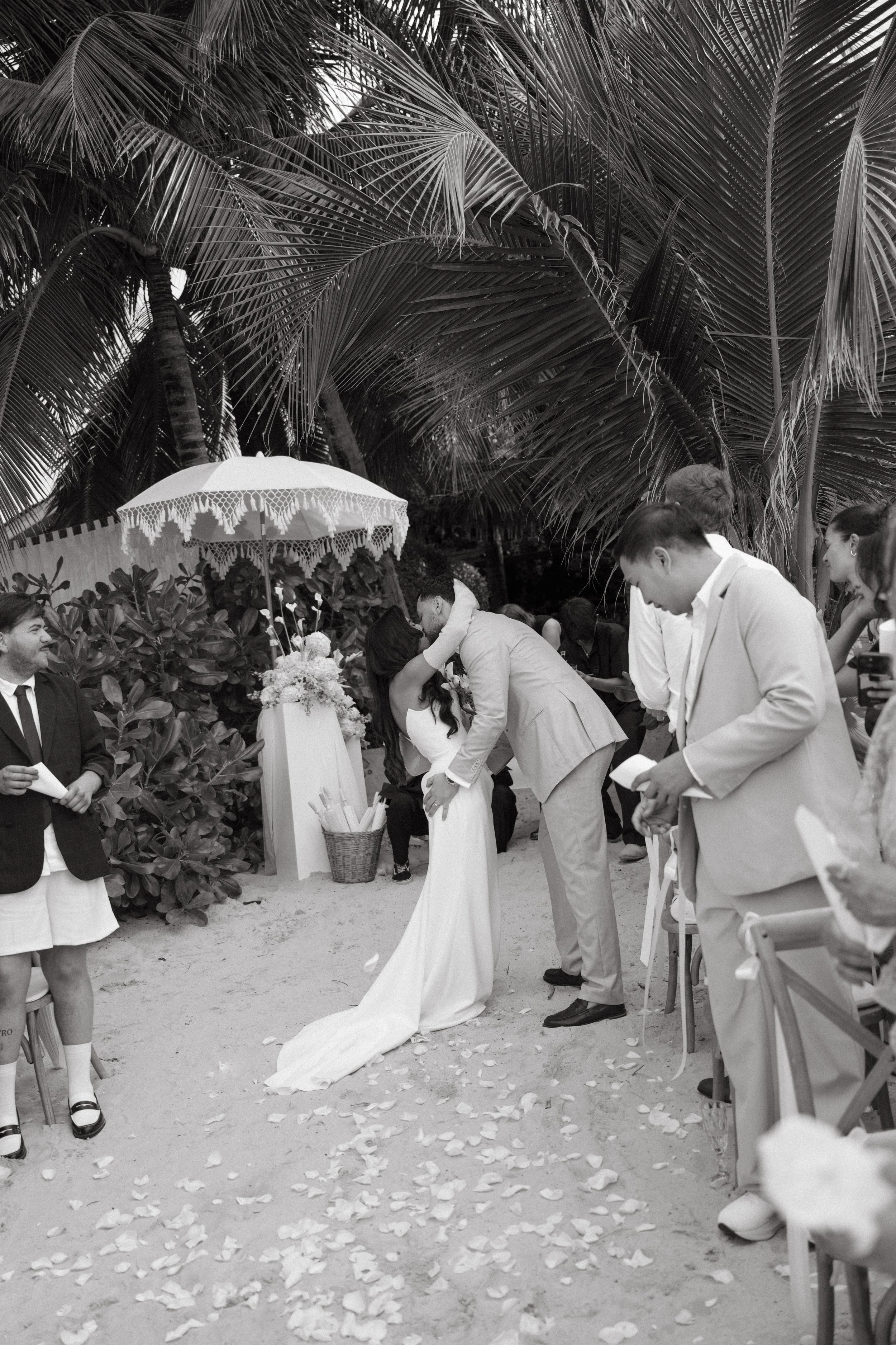 bride and groom kissing during post-ceremony cocktails at odyssey mansion in koh samui