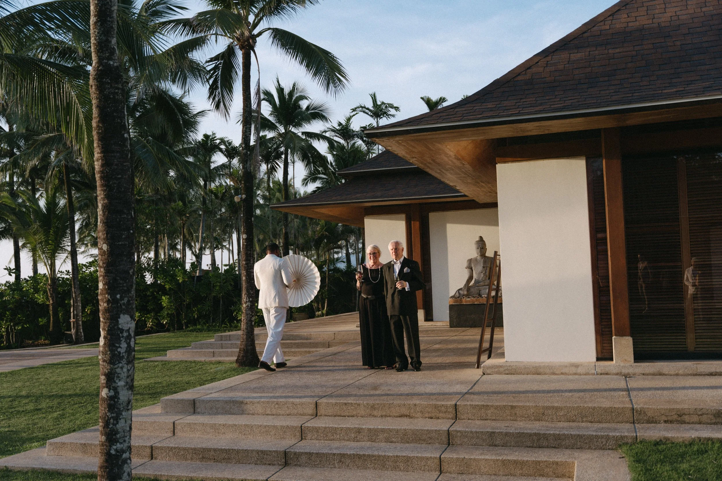 bride's parents holding drinks while waiting outside the villa at jivana beach villas