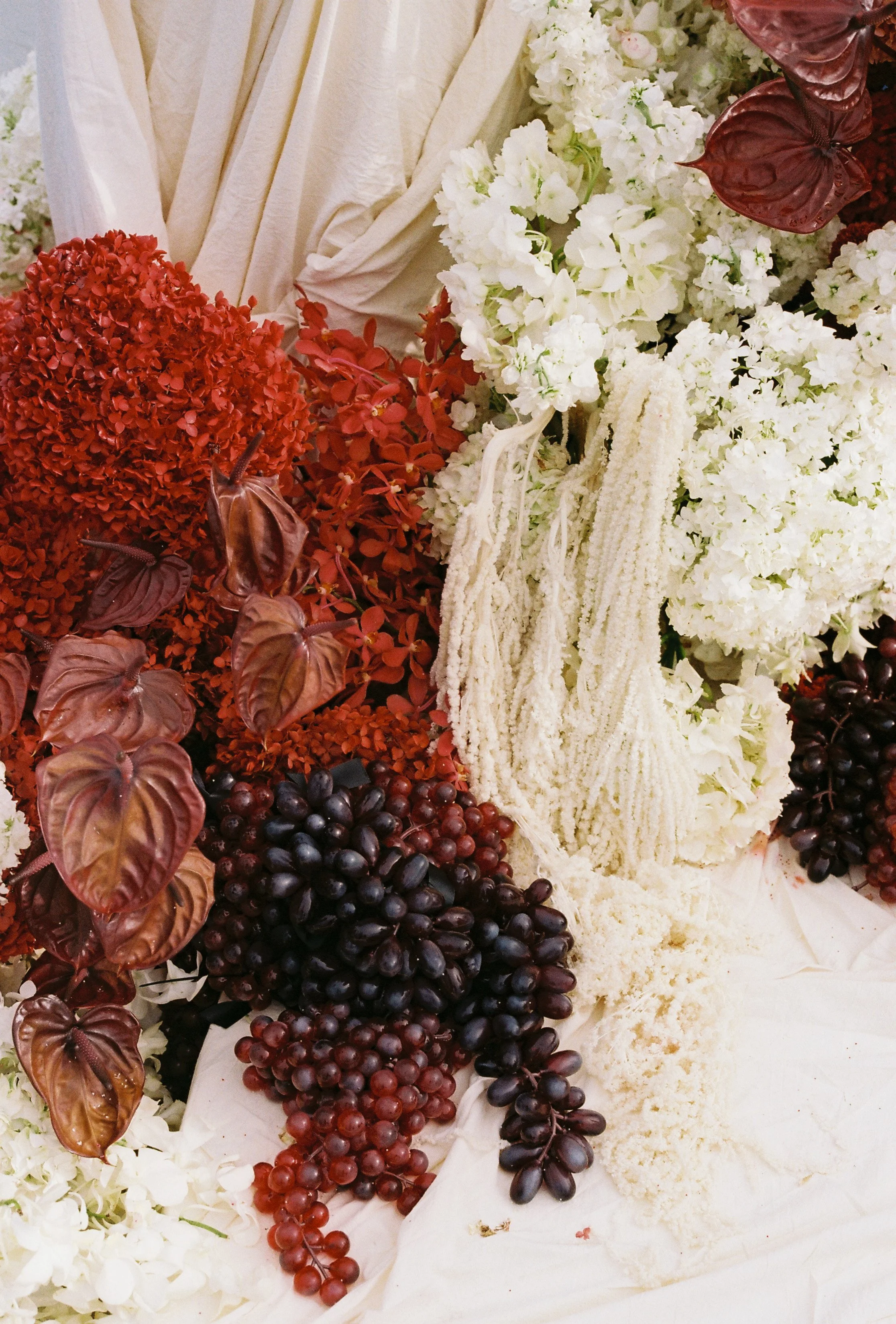 Close-up of moodyfloral installation with grapes and textured arrangements at modern Asian wedding ceremony