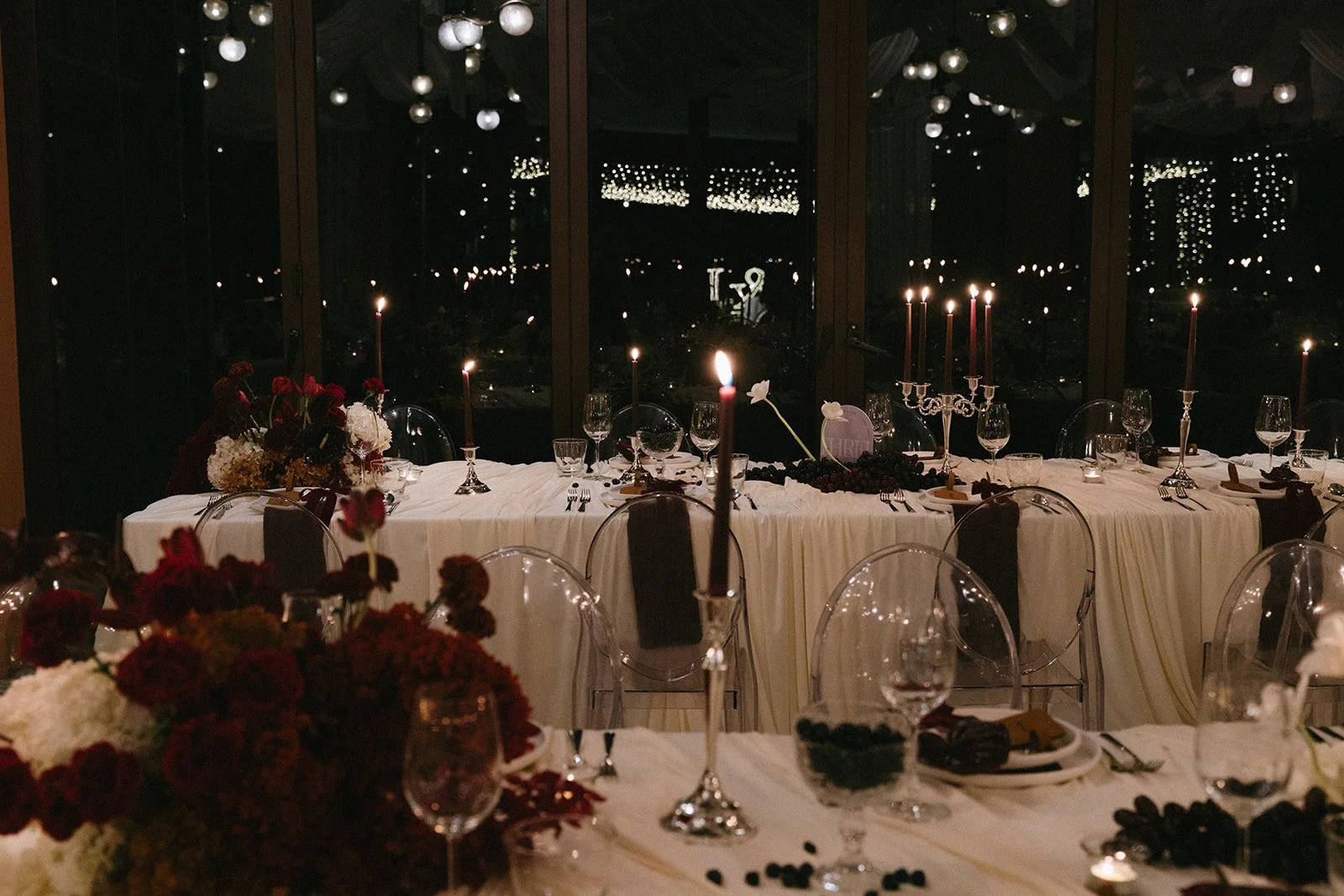 Evening reception setup at Sri Panwa with dark florals and candlelit round tables
