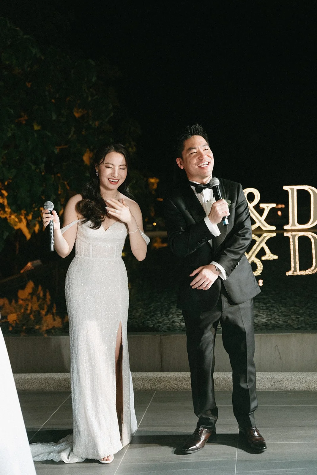 bride and groom laughing during wedding speeches at sri panwa reception